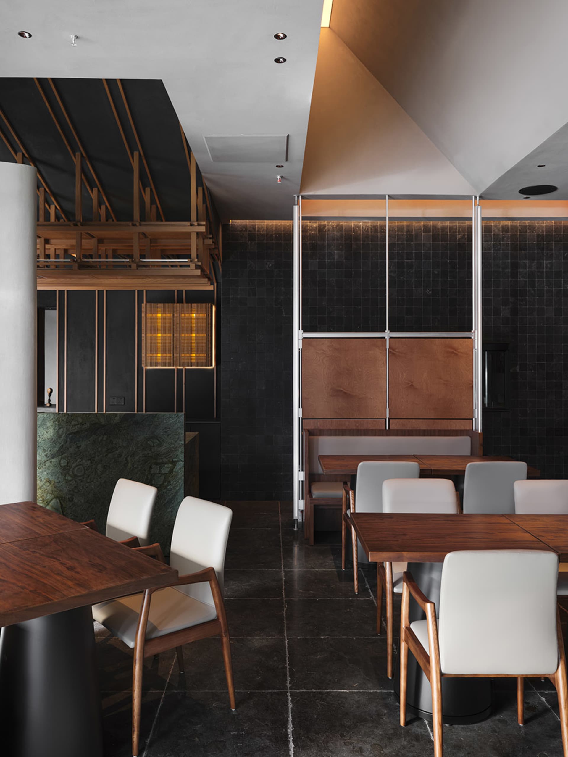 Modern restaurant interior featuring wooden tables and marble accents.