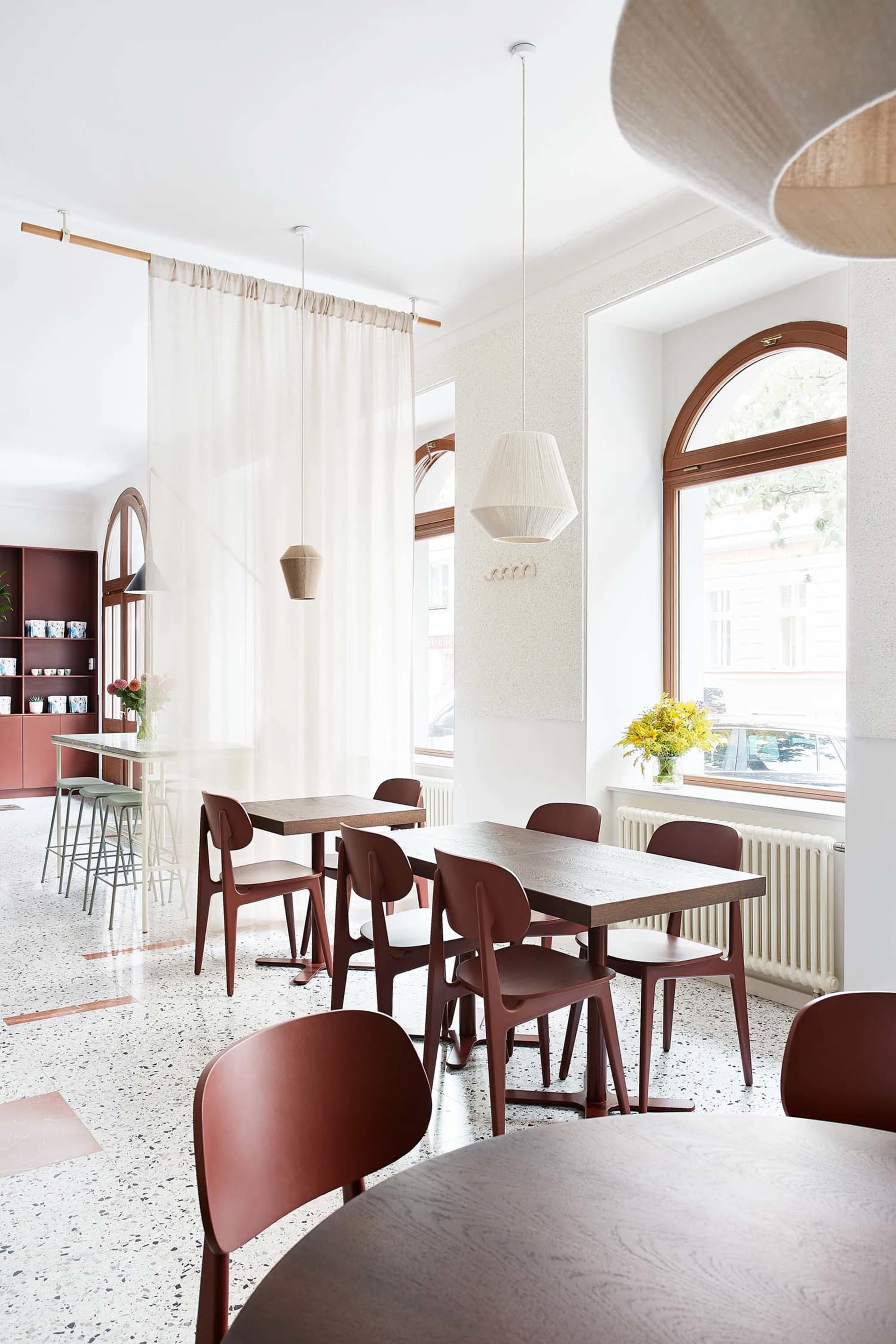 A minimalist cafe interior with wooden tables and chairs.