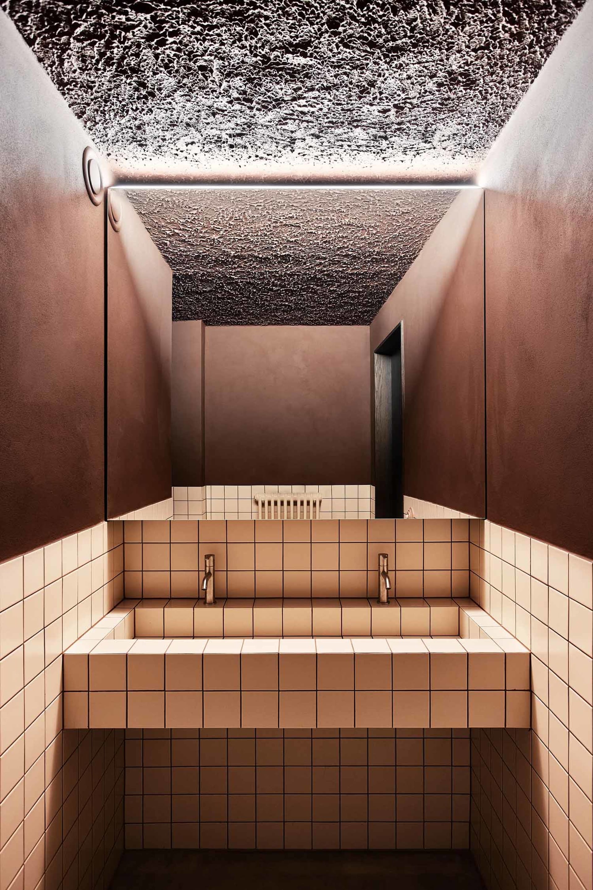 Public toilet with modern design featuring concrete walls and tiled floor