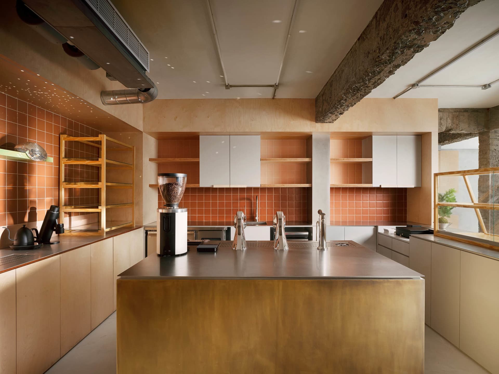 Modern industrial coffee shop featuring a metal-clad matte brass kitchen counter.