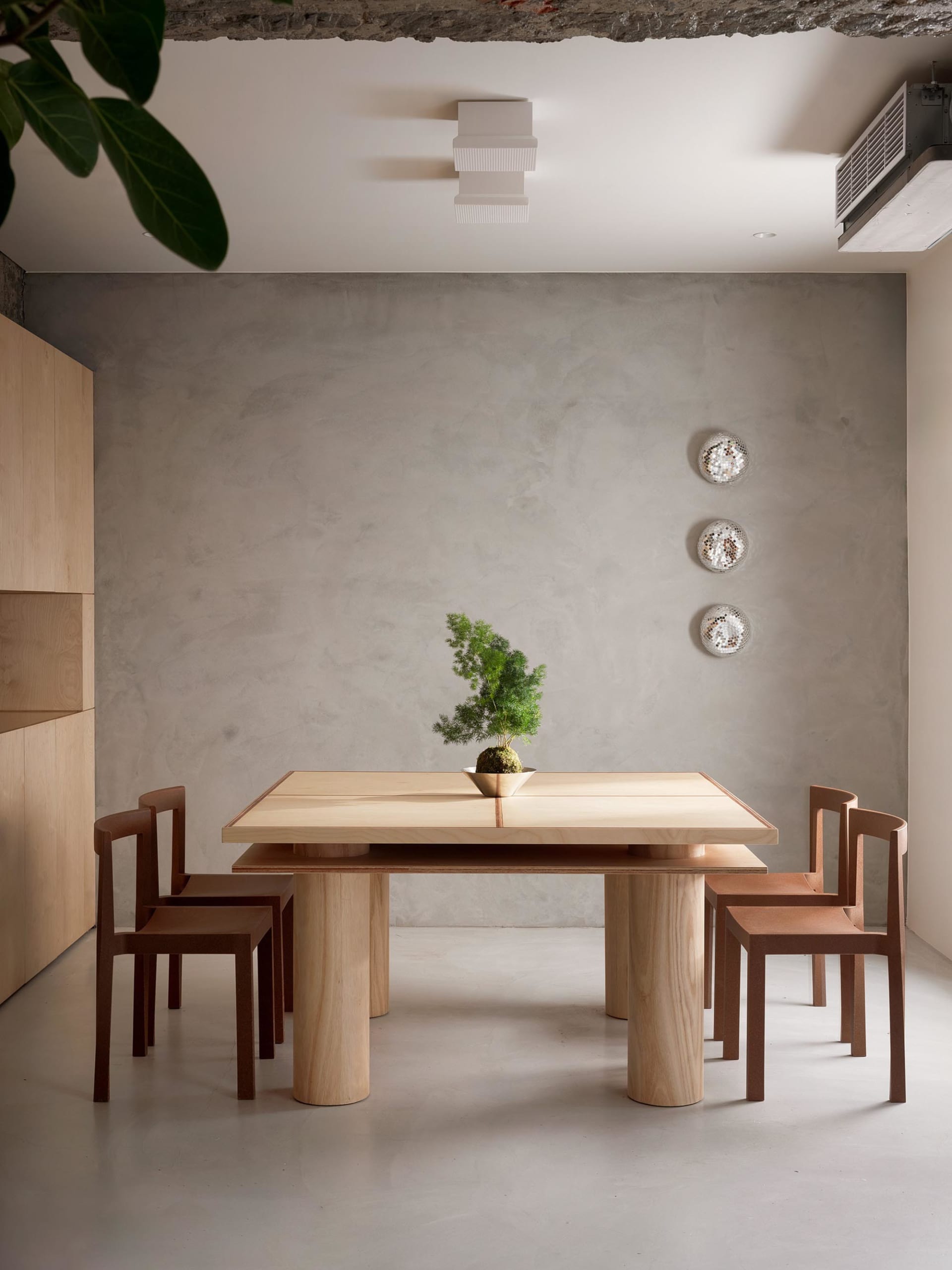 A modern wooden dining table with chairs in a minimalist interior design setting.