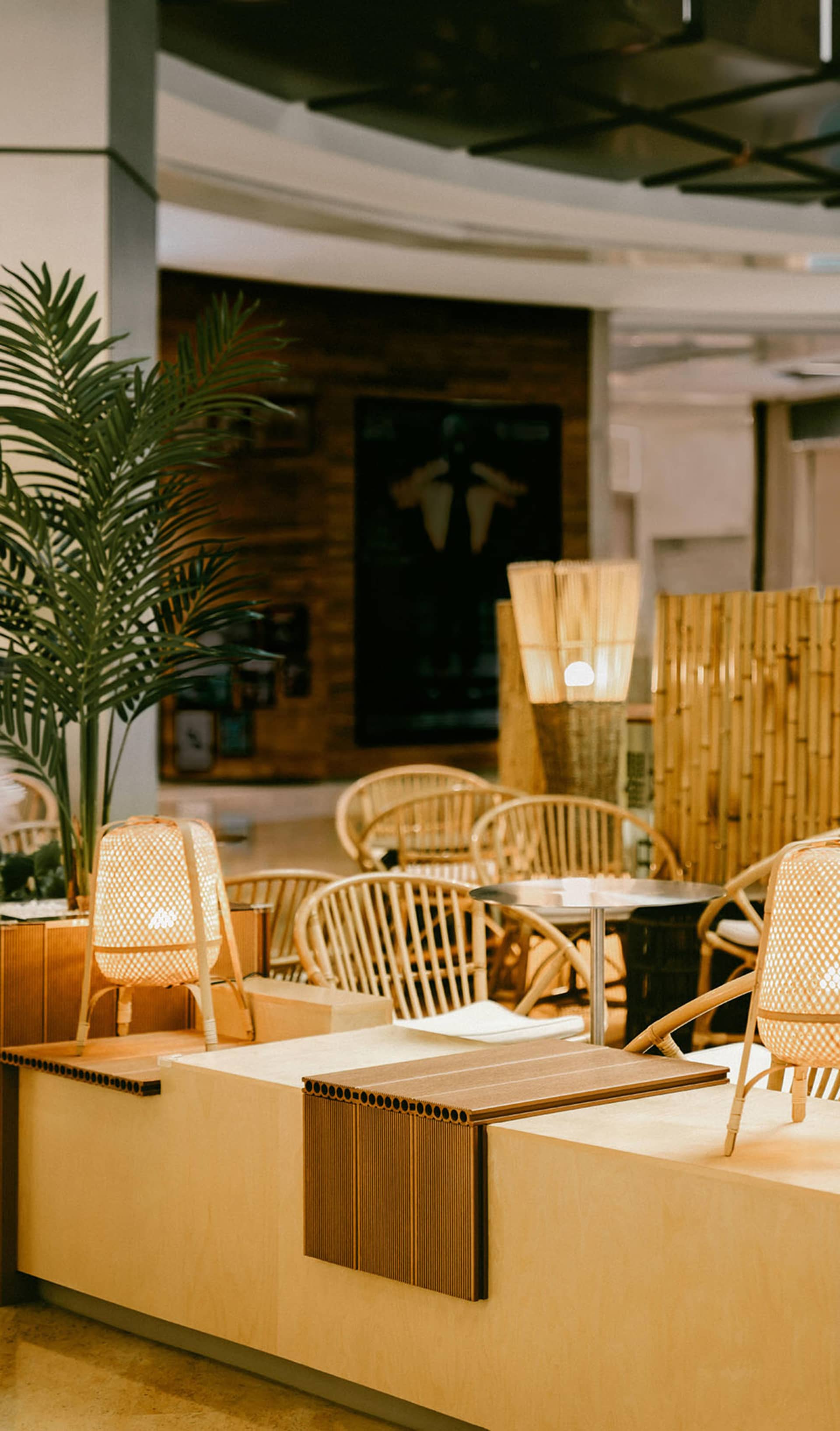 Modern restaurant interior with wooden furniture and lighting fixtures.