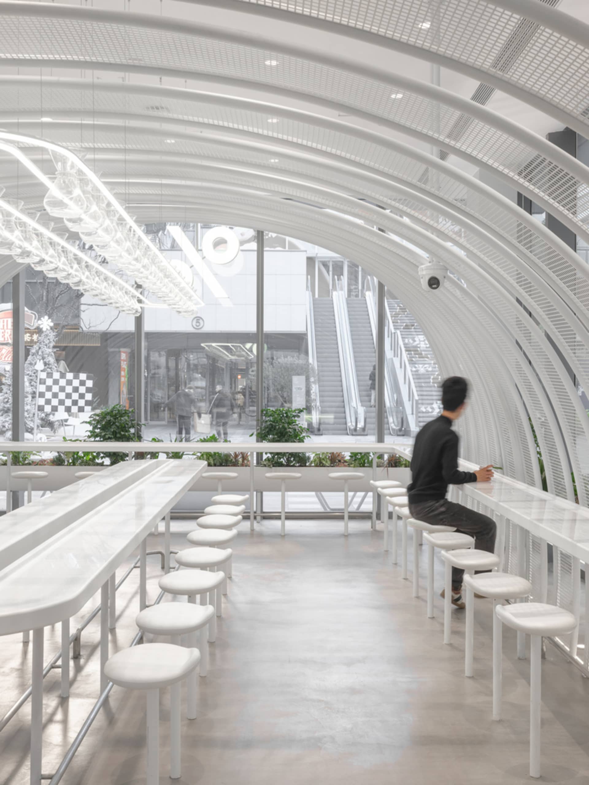 現代簡約咖啡廳室內,採用白色材質與混凝土地板。