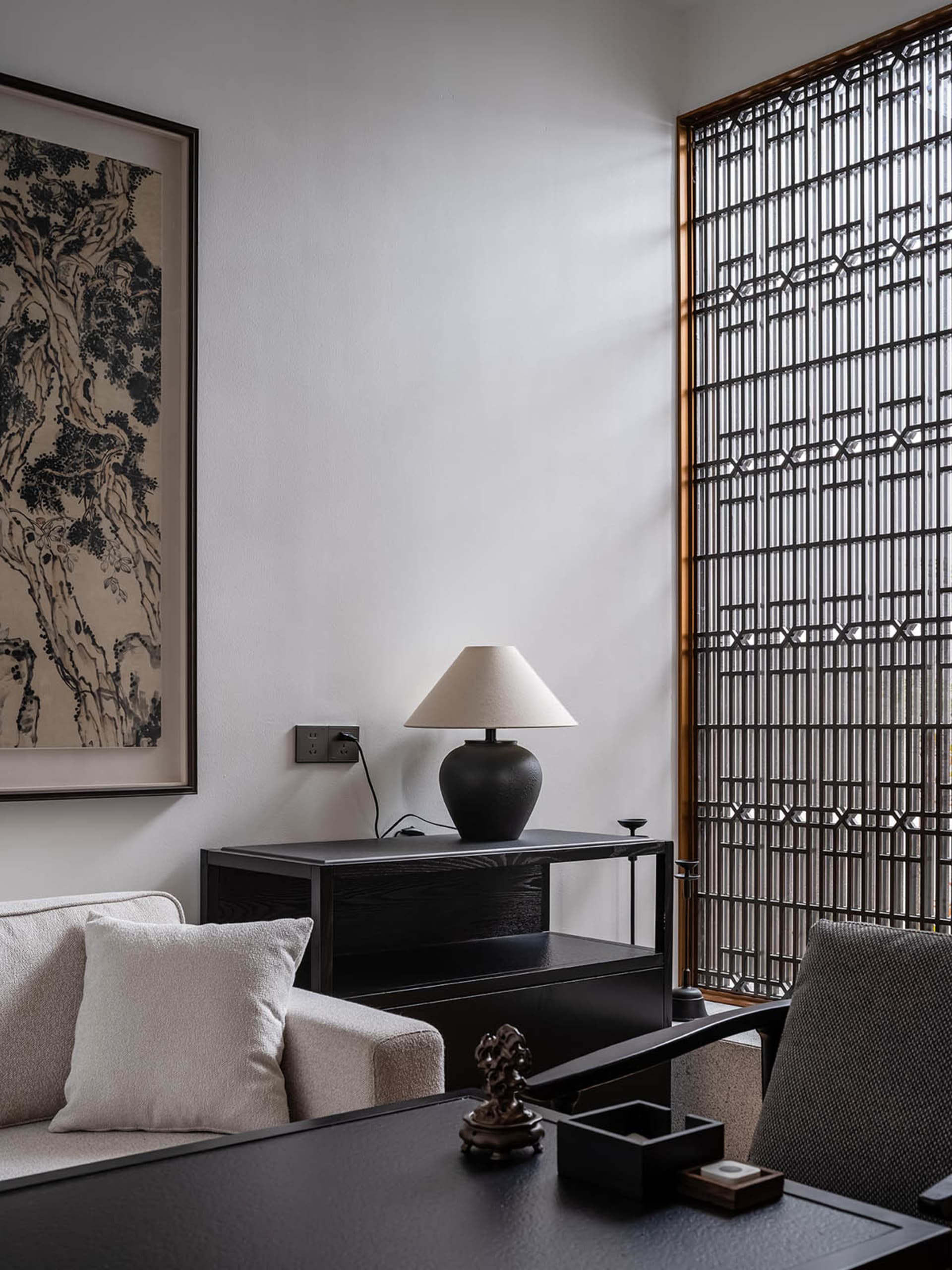A modern minimalist living room featuring black furniture and neutral tones.