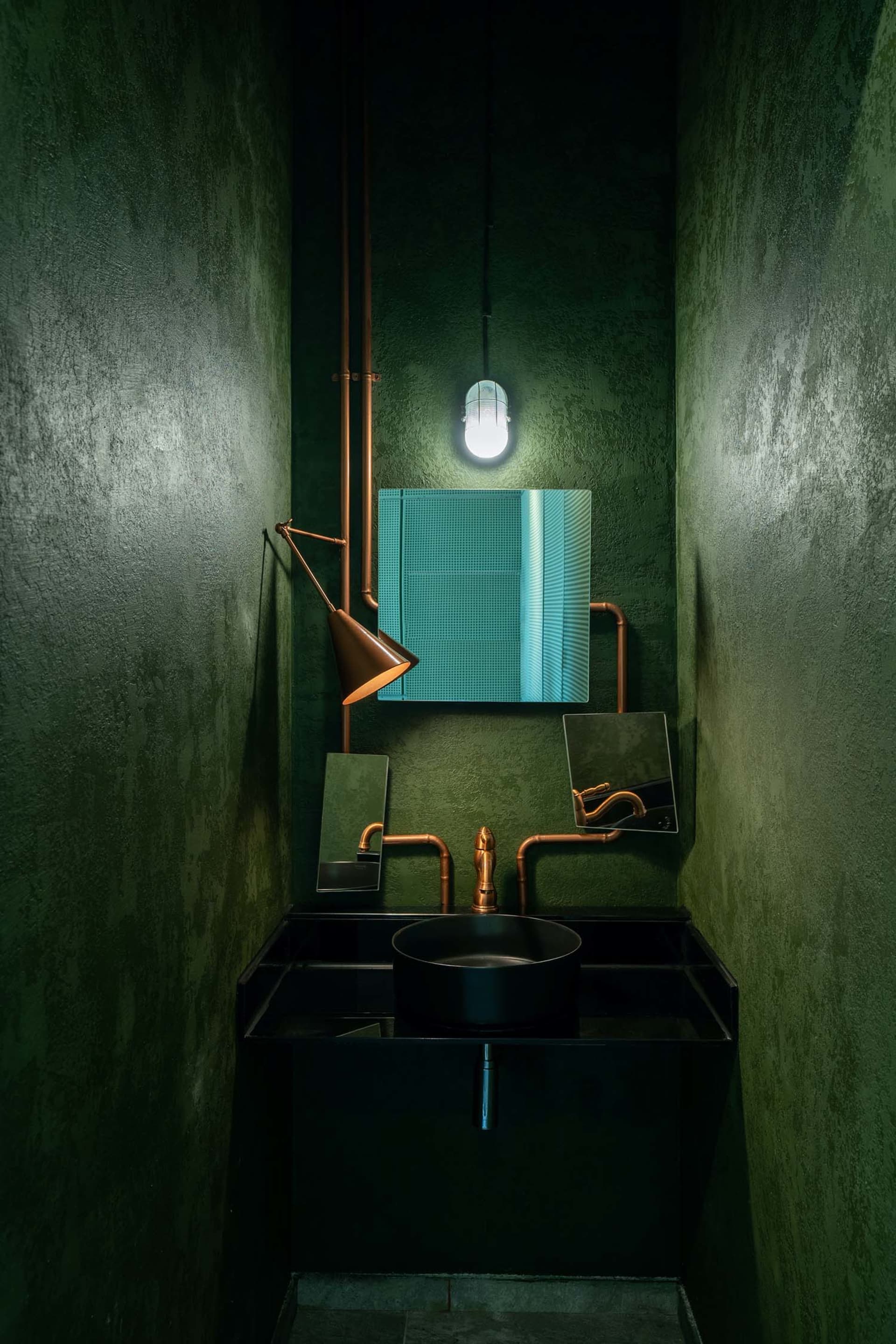 Modern bathroom with metallic elements, including sink, faucet, and mirror, featuring a minimalist design.