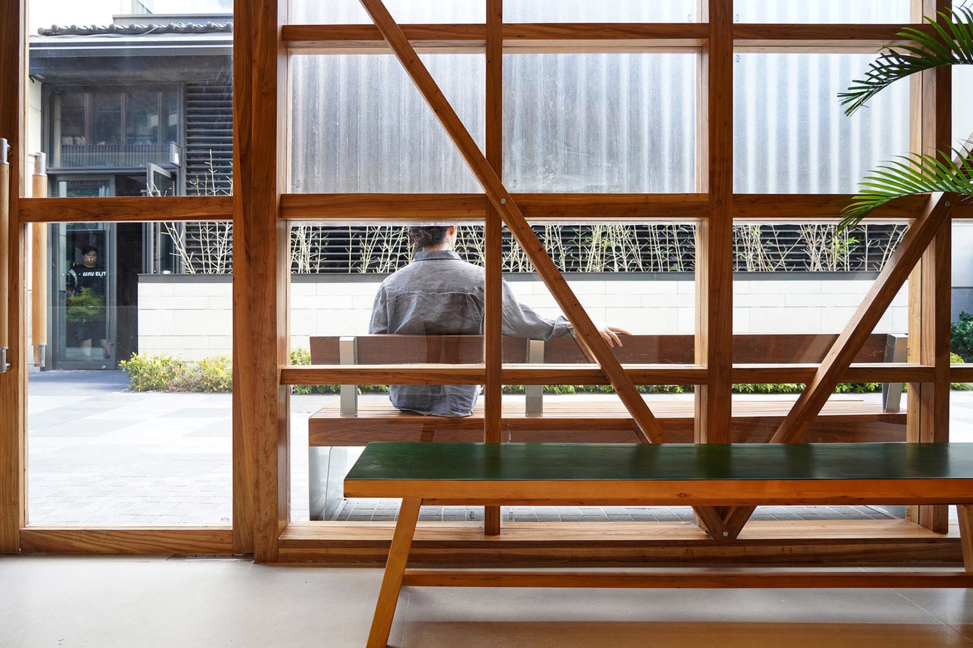 A modern restaurant bar with wooden furniture and green plants.