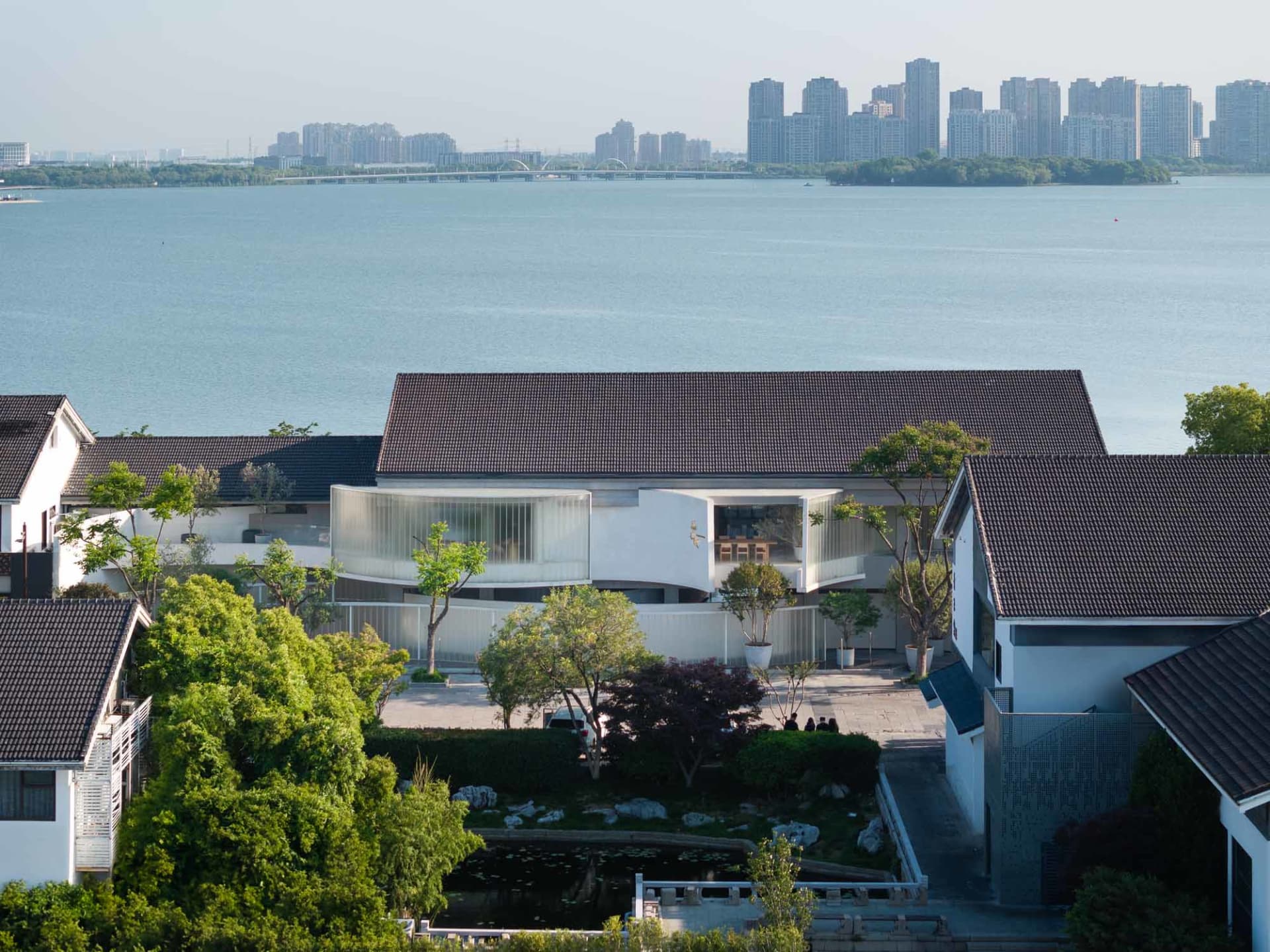 現代住宅採用玻璃、混凝土與木質元素,坐落於水邊