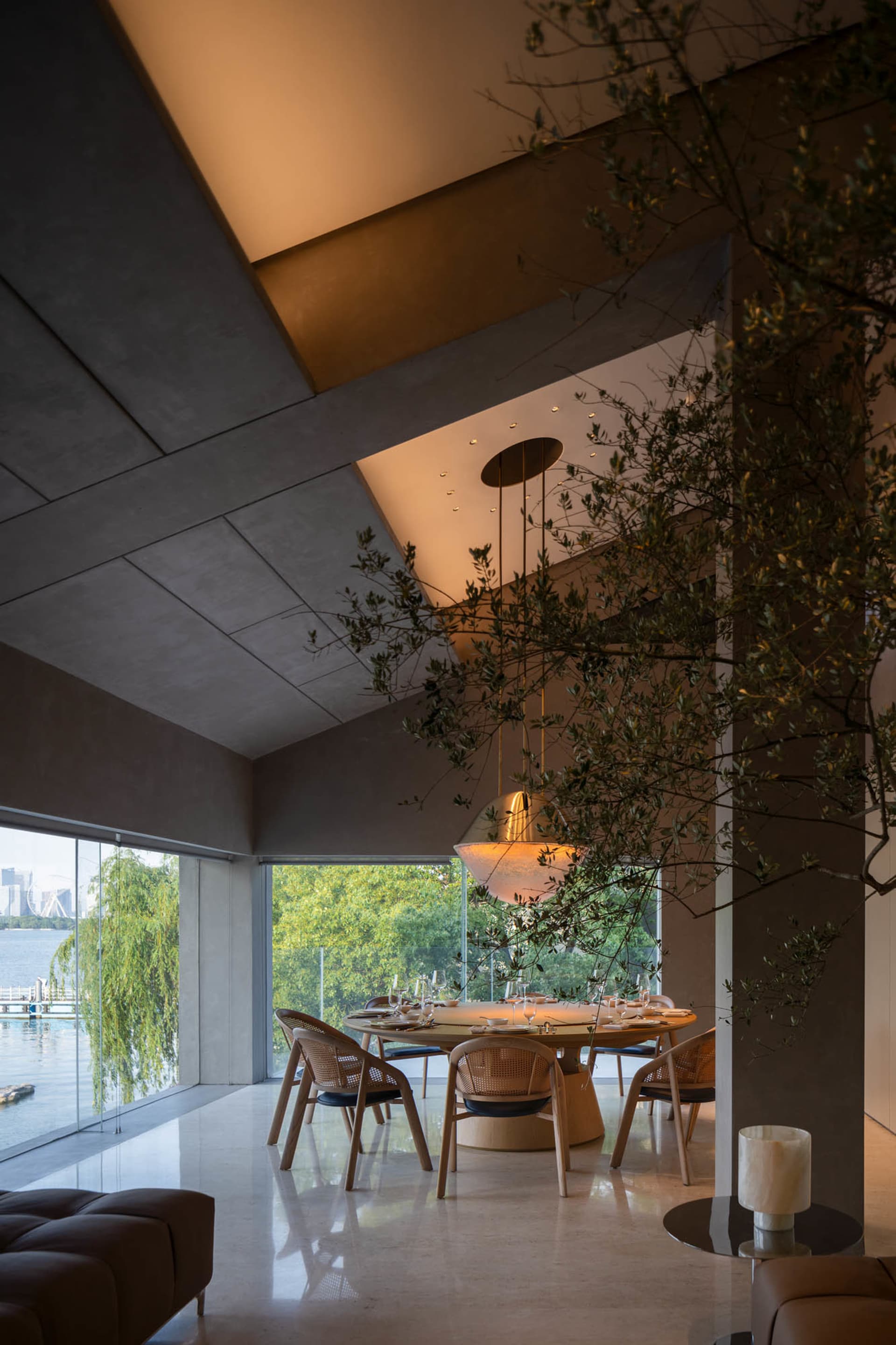 An elegant, modern residential dining room with minimalist design and concrete walls.