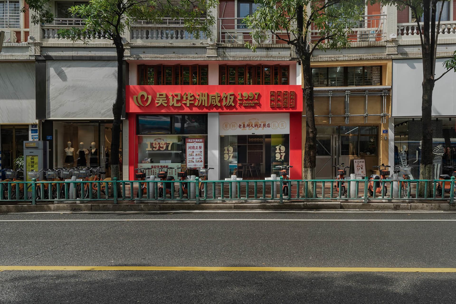 A city street scene featuring a storefront with a red awning and glass windows.