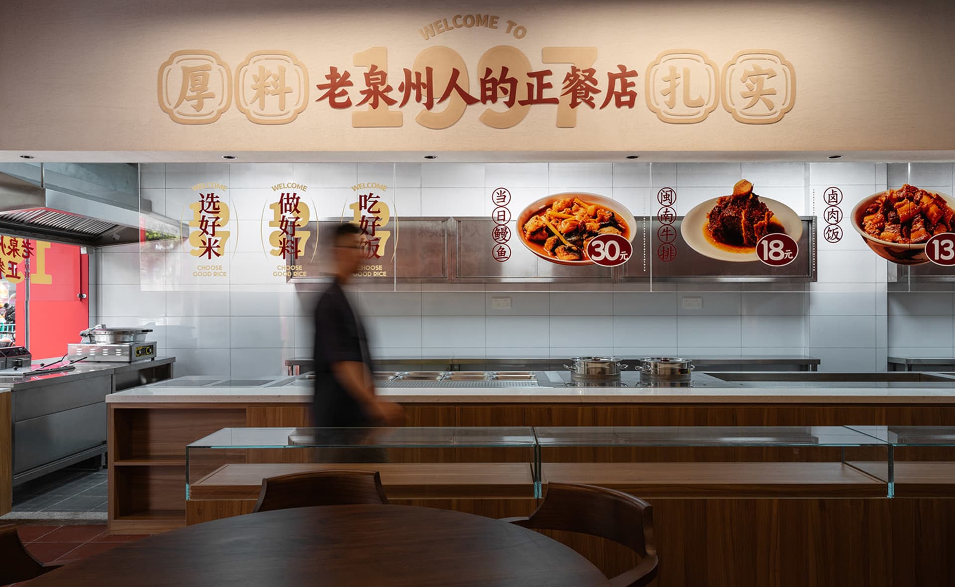 A modern restaurant food court counter featuring granite countertops and a menu displayed in the background.