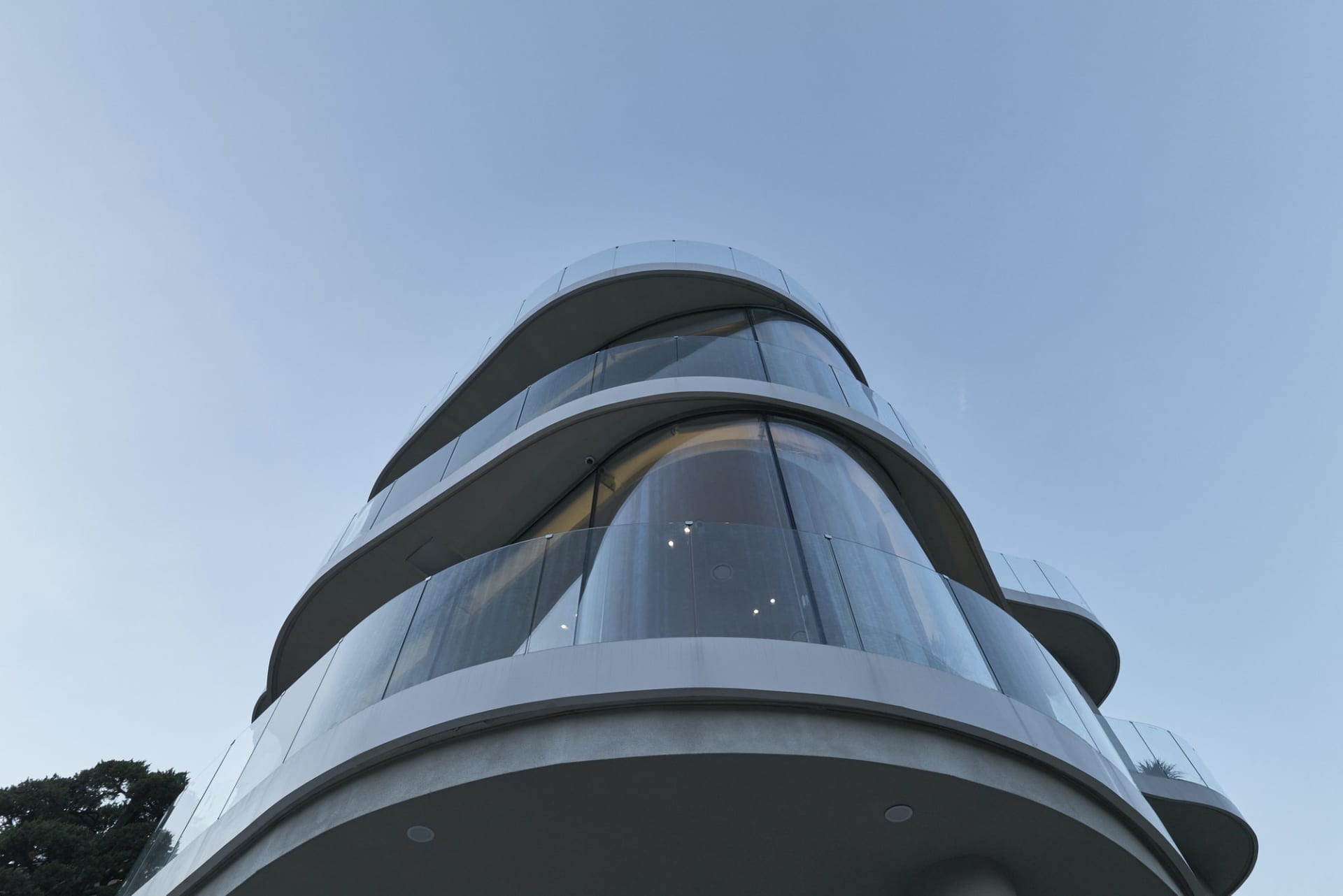 Modern architectural design featuring curved glass frontal exterior surfaces of a tall skyscraper.