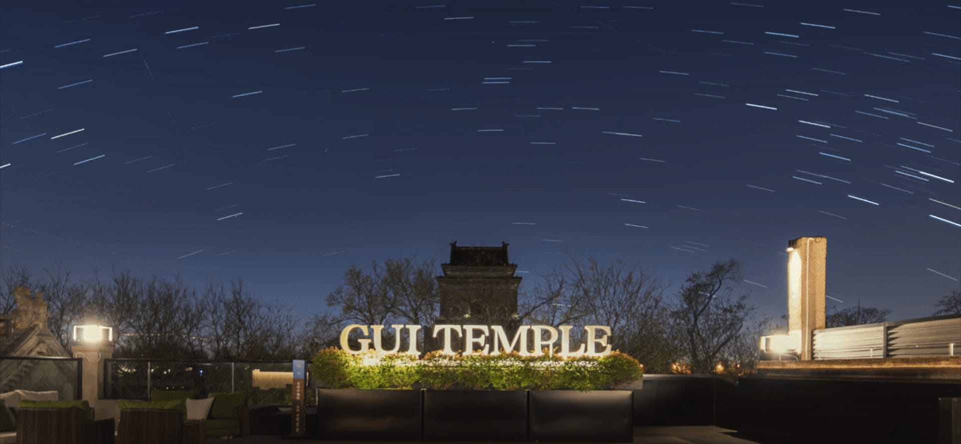夜空繁星與前景寺廟招牌，由戶外燈光照亮。
