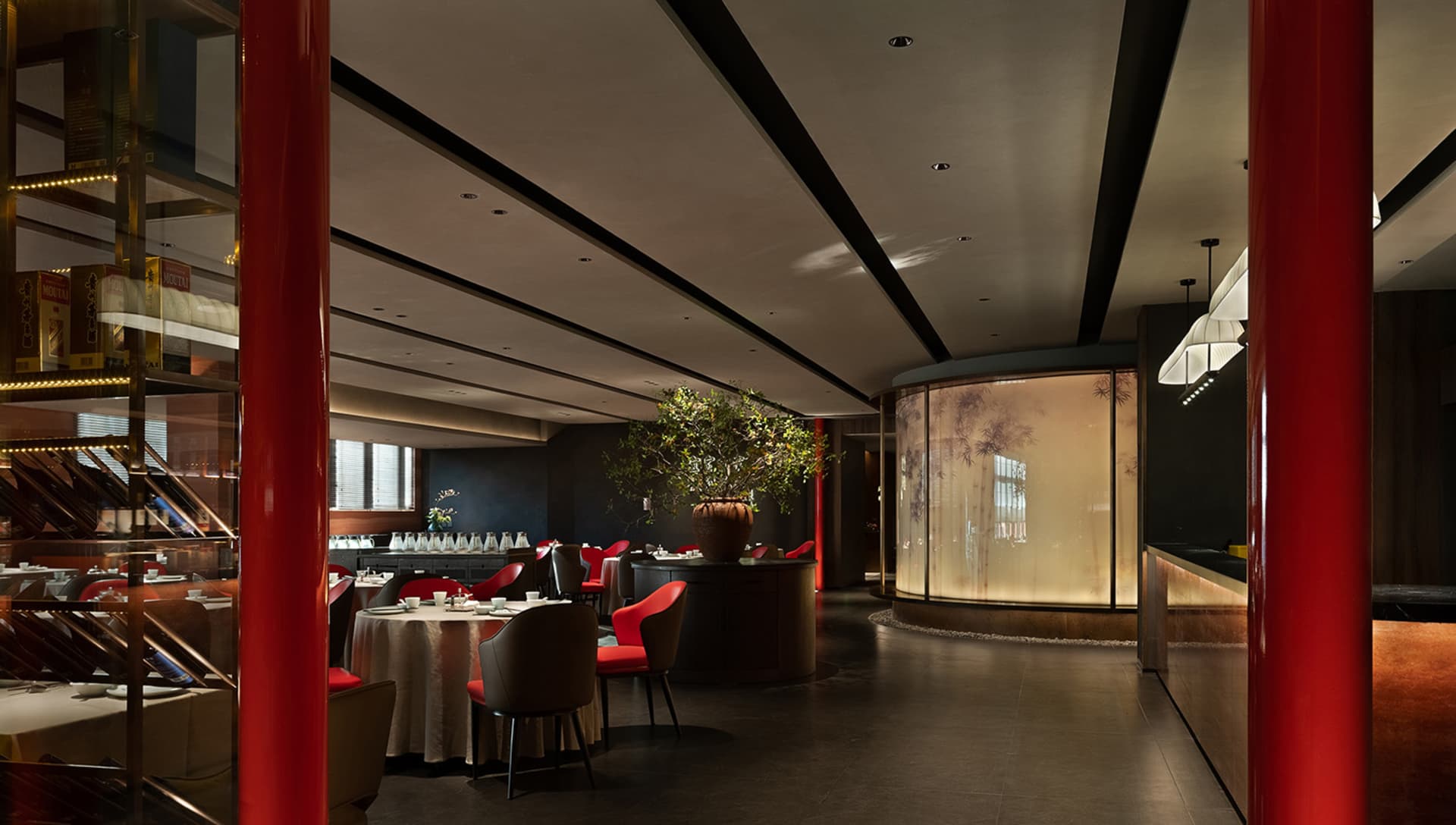 Lush luxury Chinese cuisine restaurant with tables set for service, red and black hues dominate the palette, and large potted