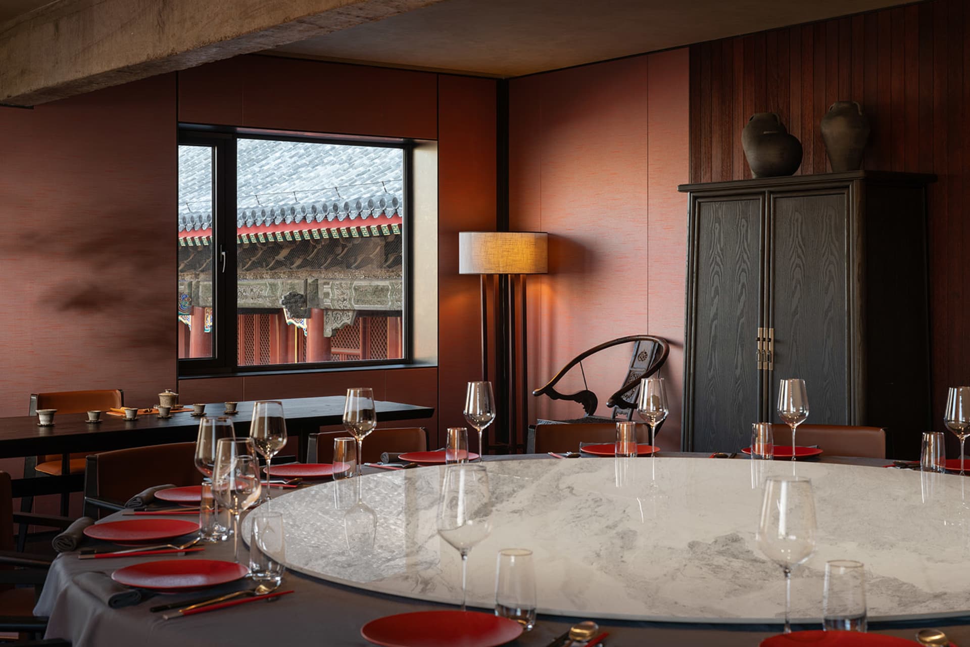 Modern restaurant dining room with marble tables and red accents