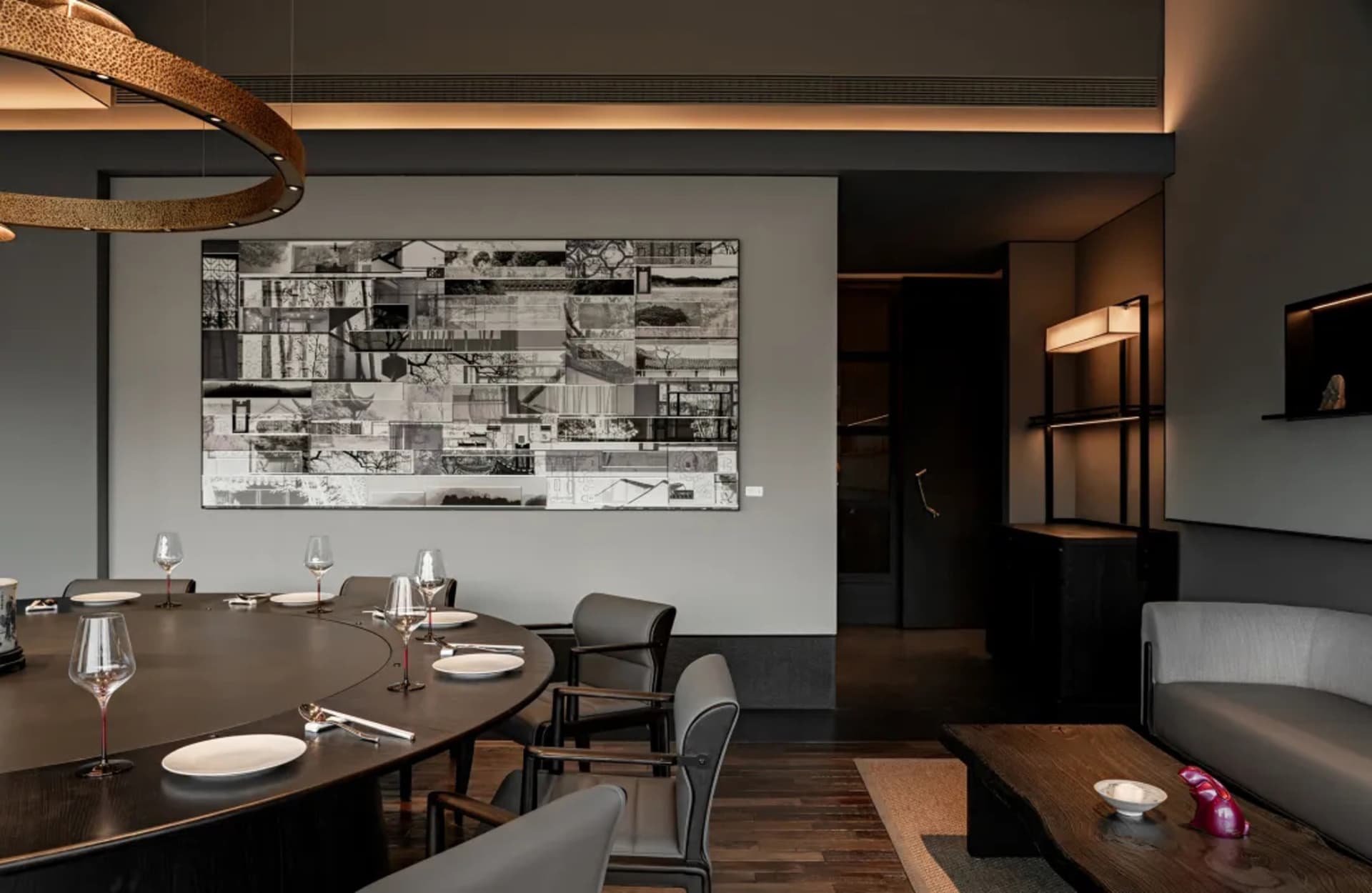 Modern living and dining area with grey concrete finishes and a large black and white wall art.