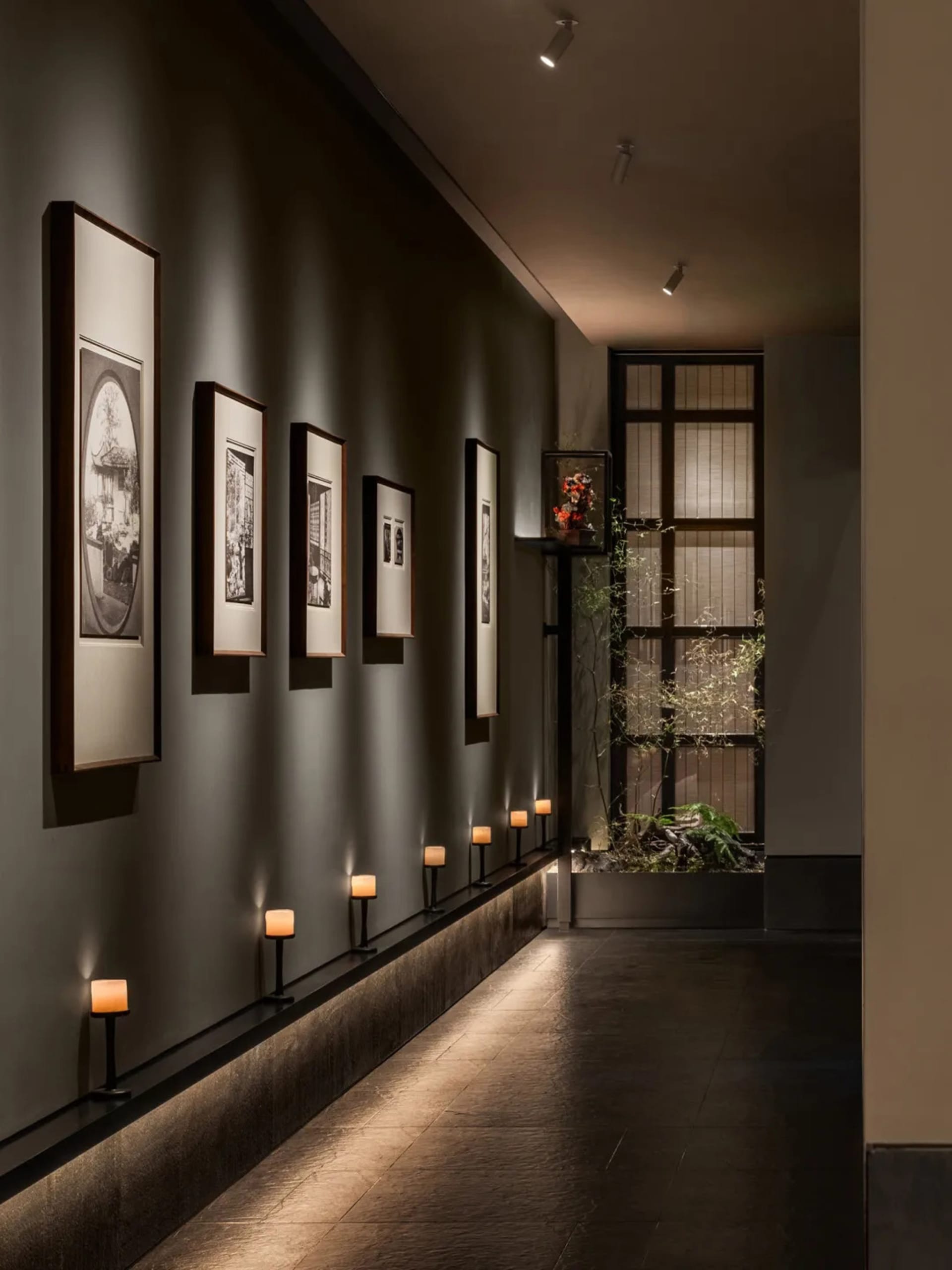 A minimalist corridor featuring concrete flooring and lighting fixtures.