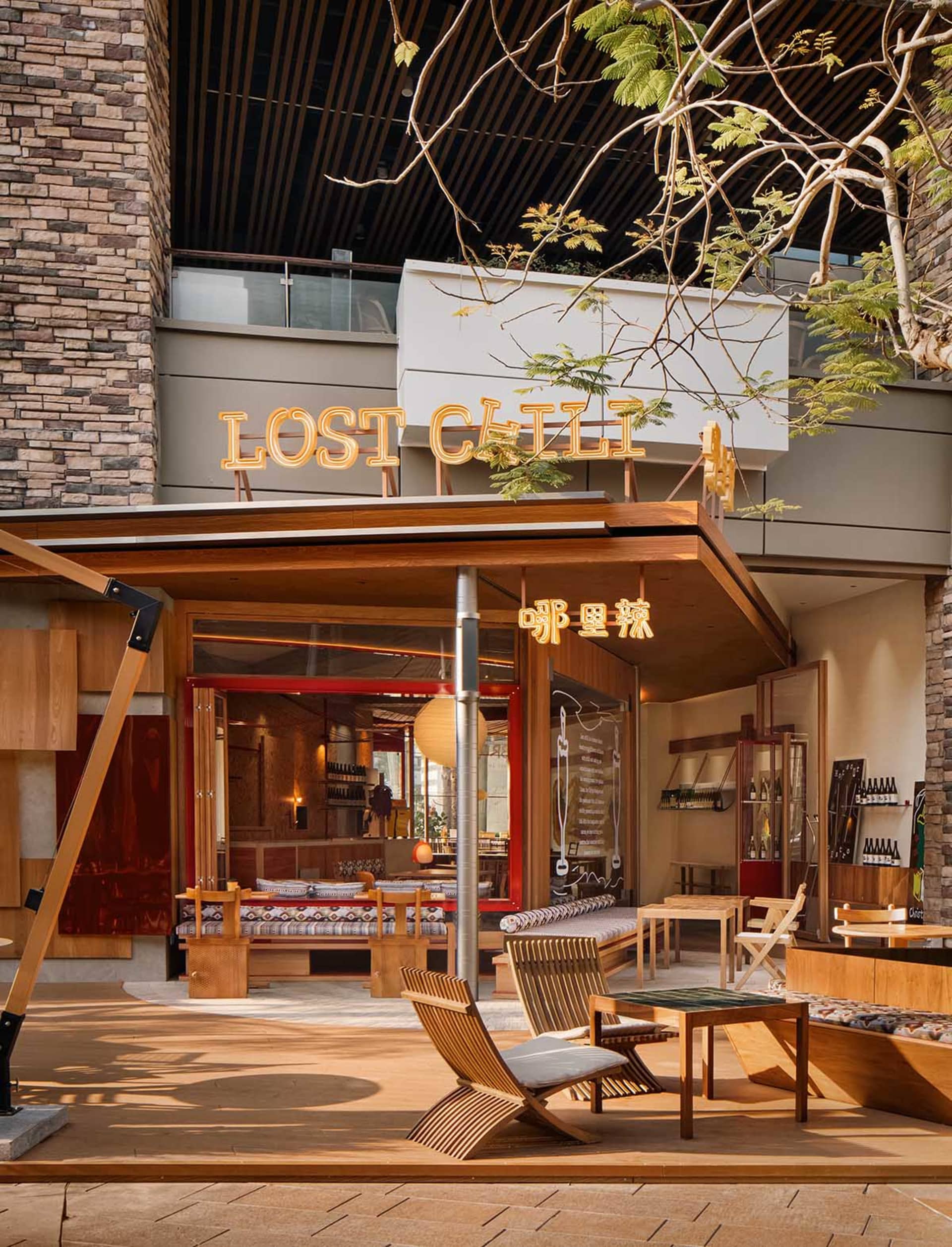 Outdoor patio of a modern restaurant with wooden furniture and structural elements.