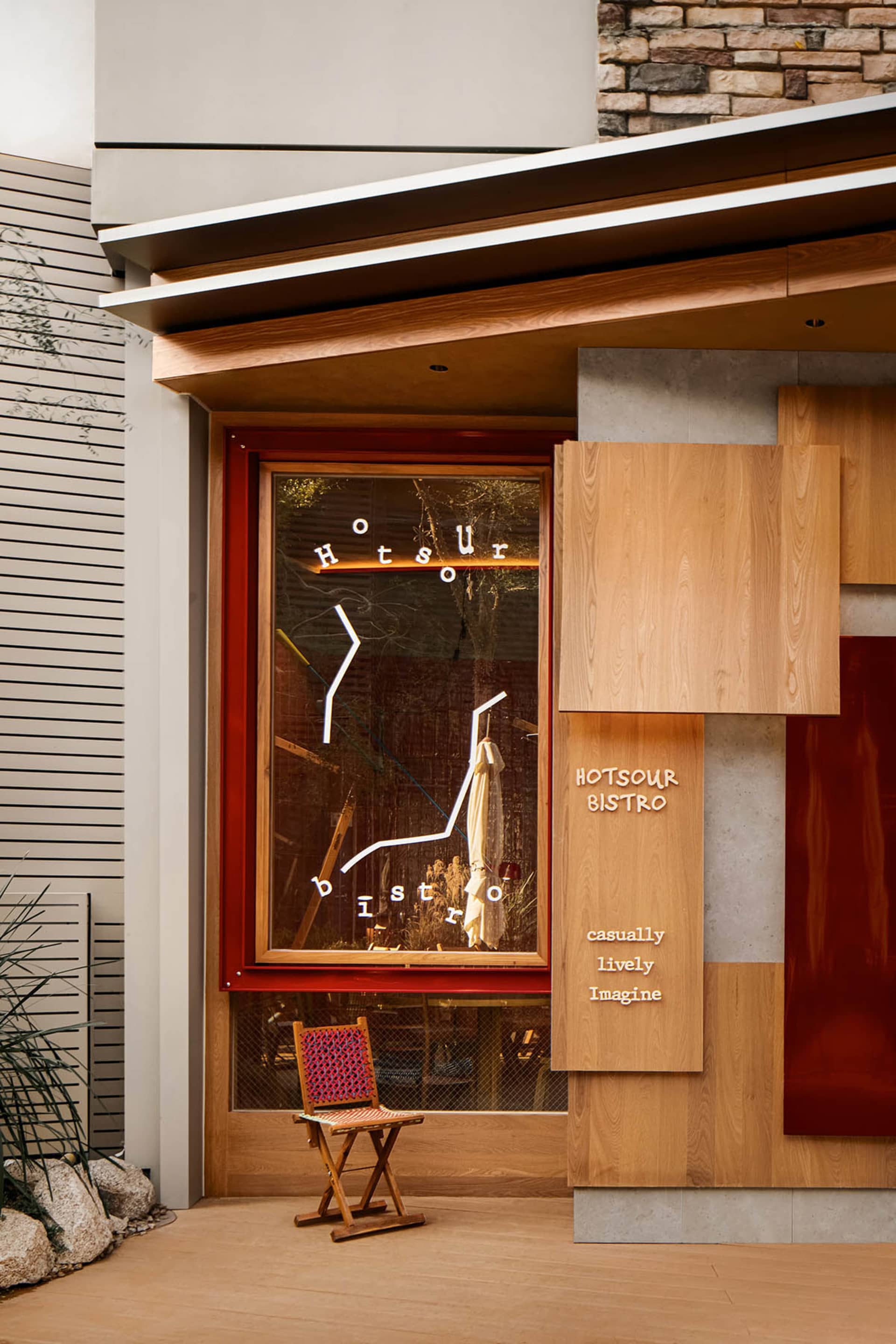 現代零售店面，木質櫥窗展示搭配霓虹燈招牌、座位區，以及乾淨的當代設計。