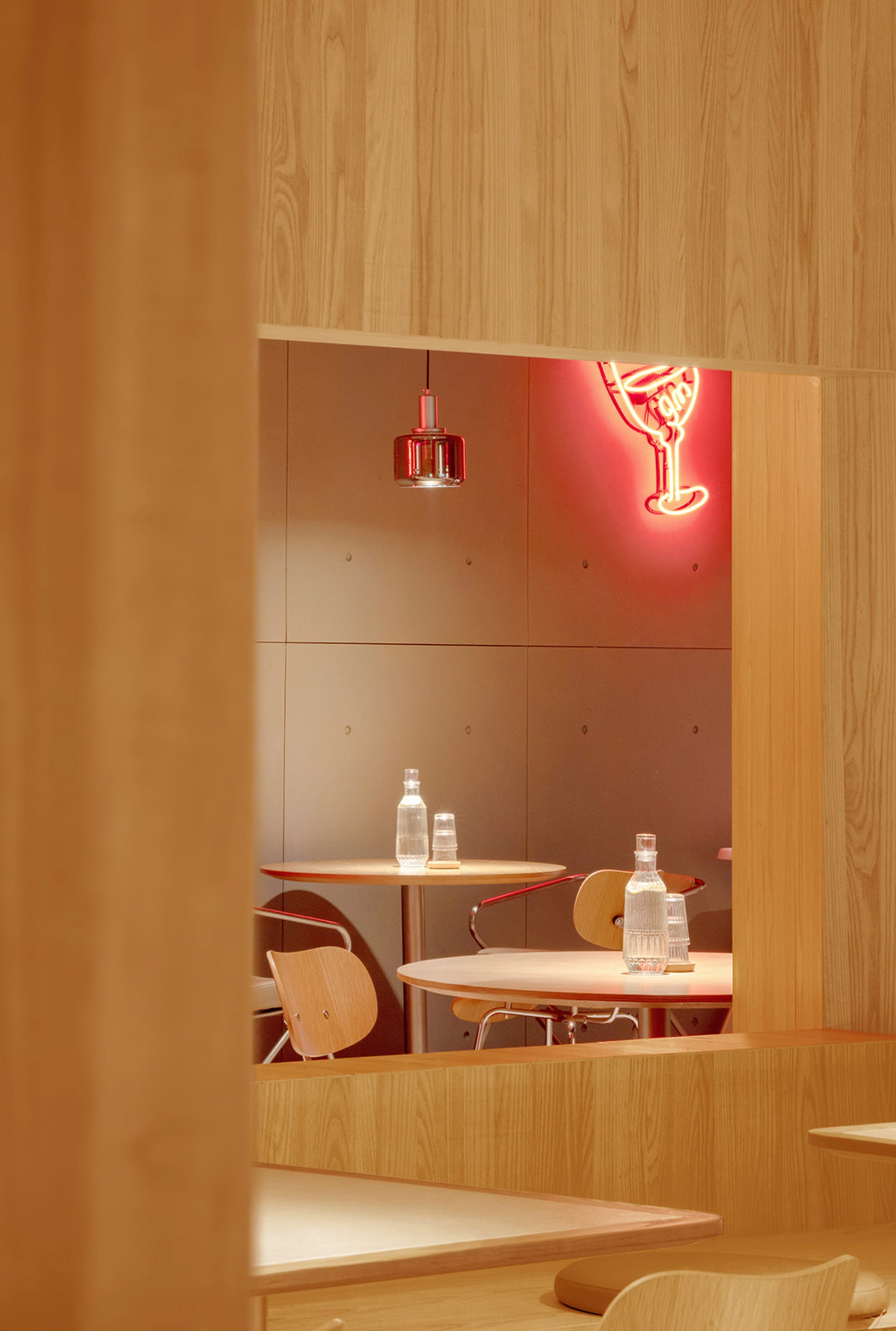 Modern cafe interior with wooden furniture and white walls.