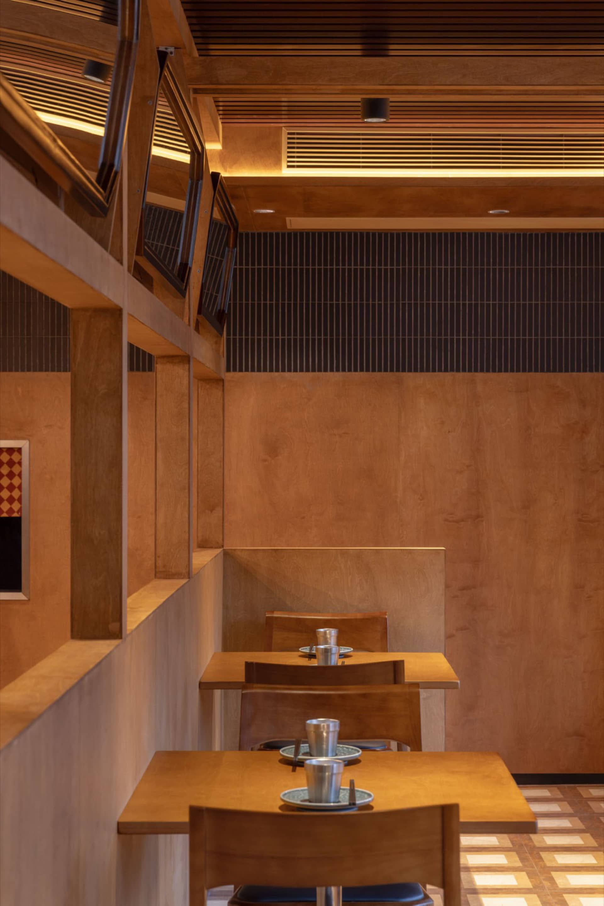 A modern restaurant interior featuring wooden panels and seating