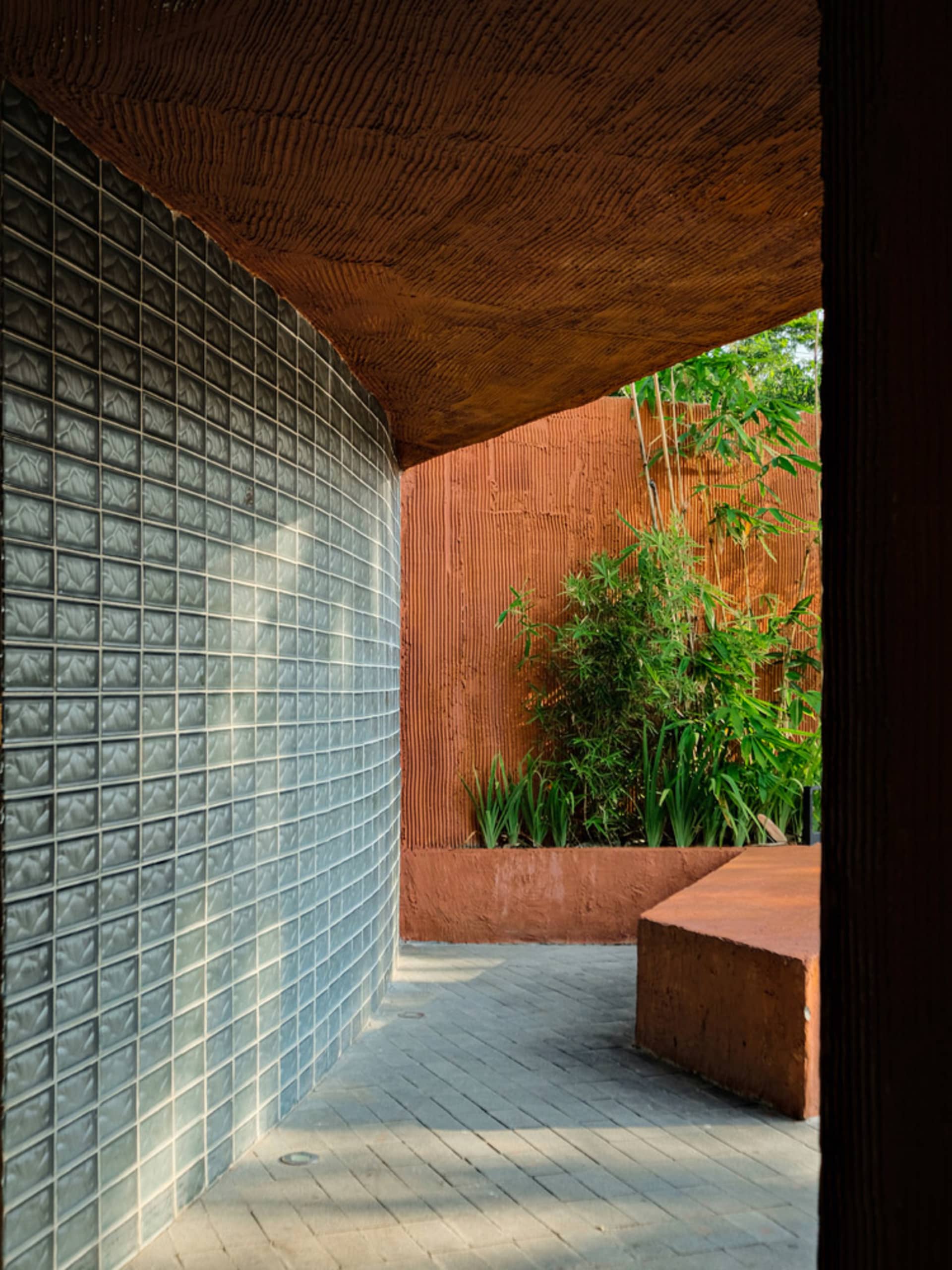 Modern outdoor space featuring glass blocks and red earth material