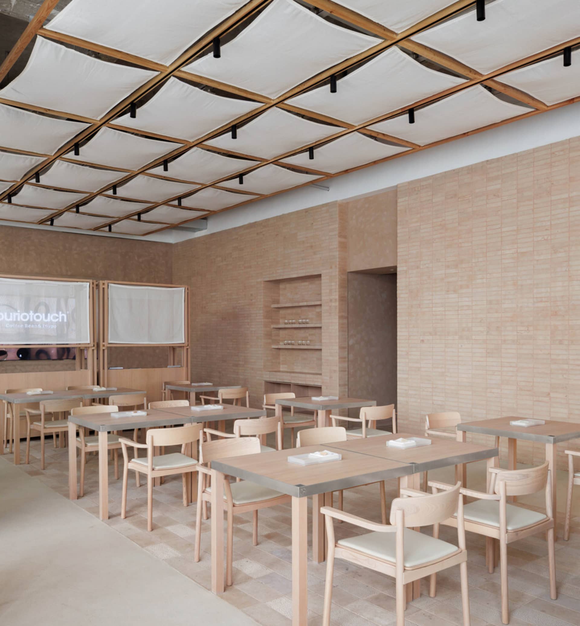 Modern restaurant interior design featuring wooden tables and concrete floors.