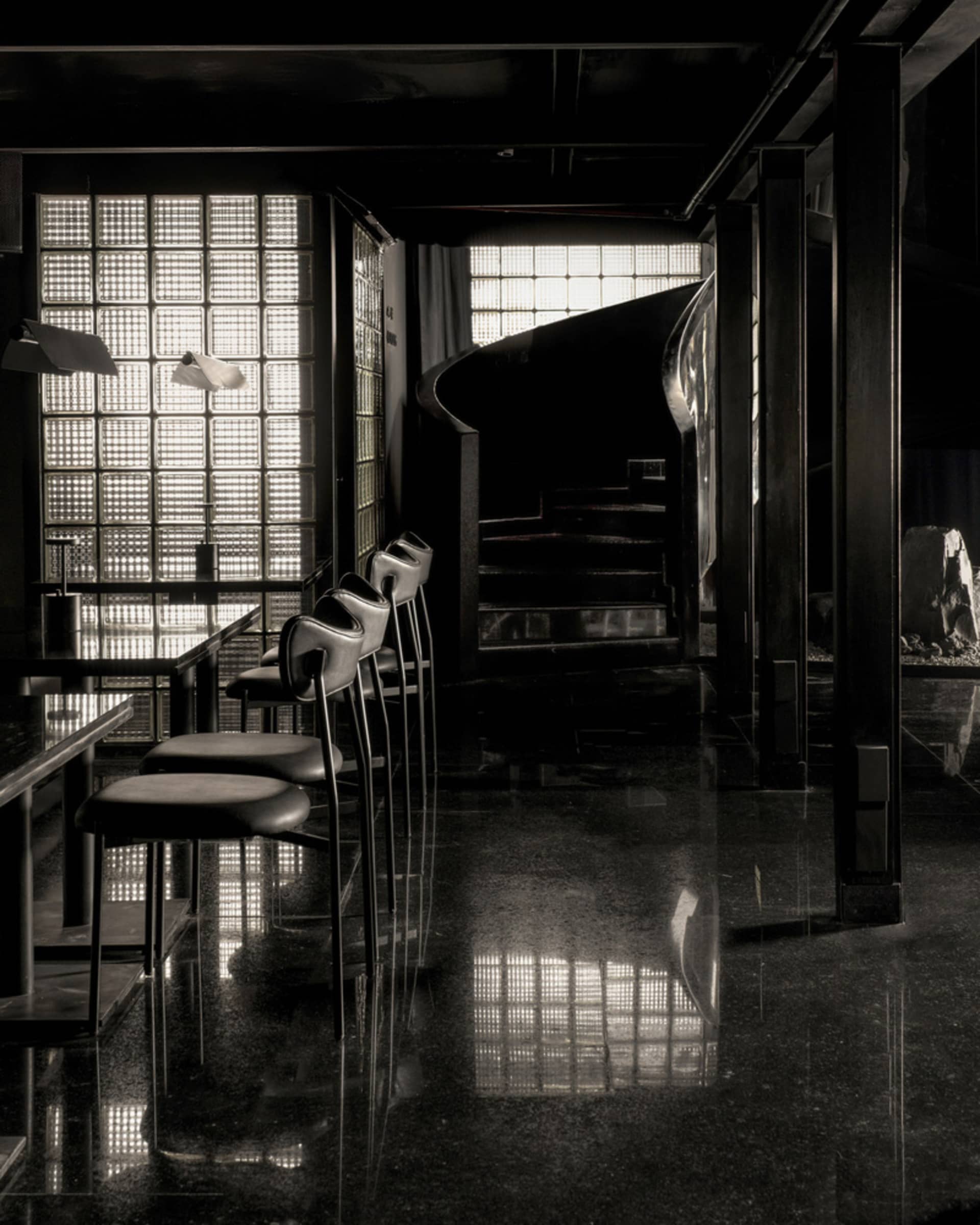 A modern minimalist bar with concrete seating and floor.