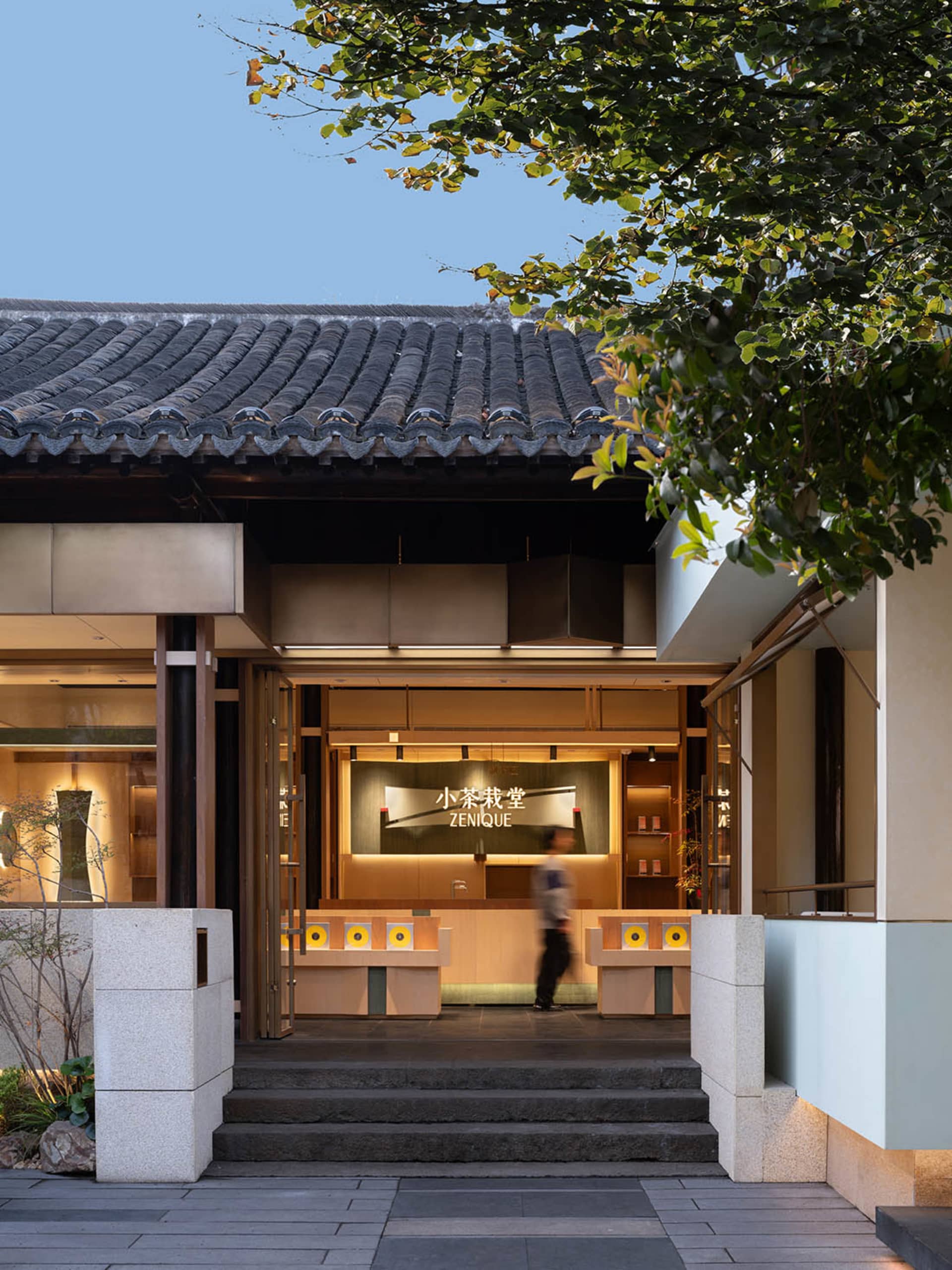 A modern retail storefront featuring glass walls and stone accents.