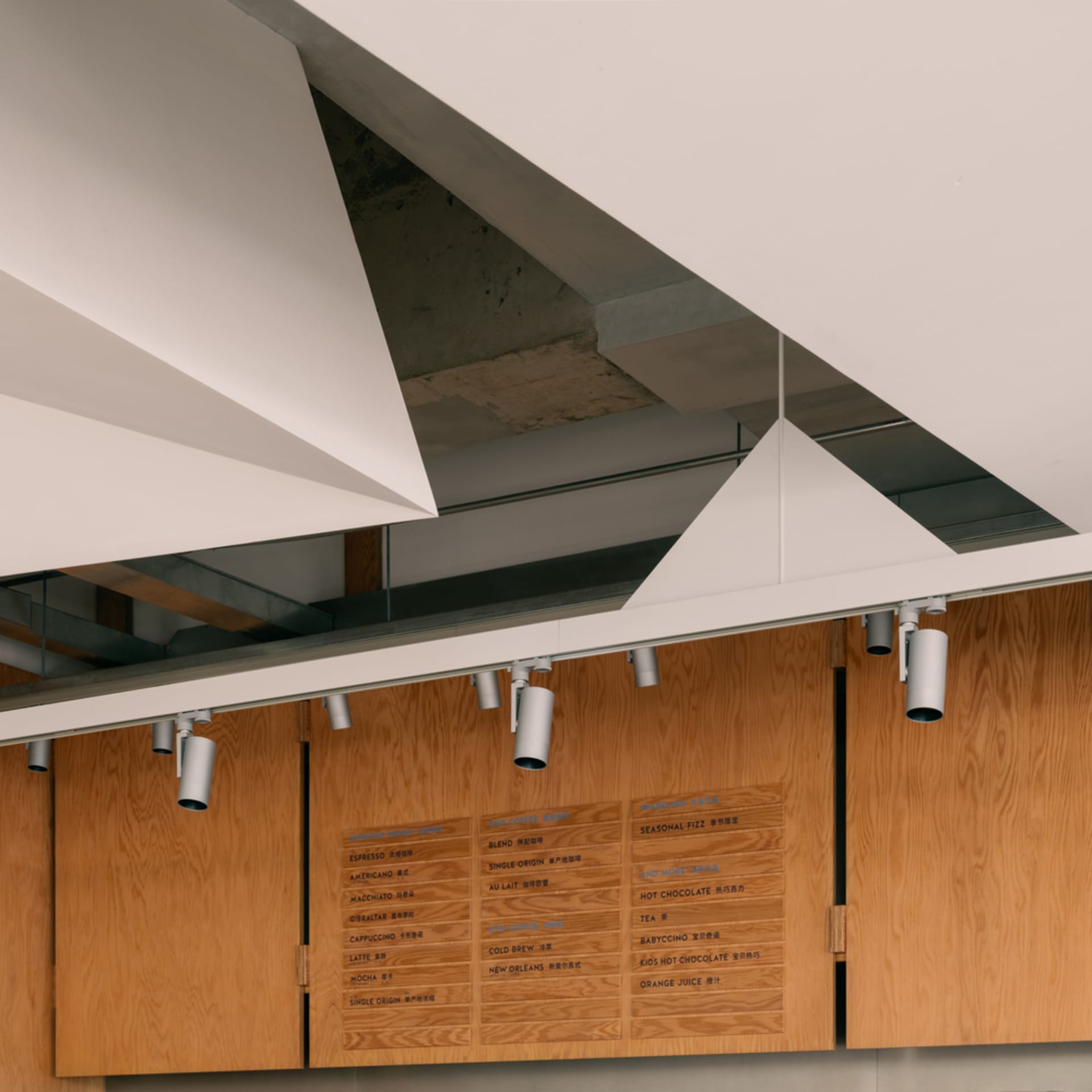 Modern coffee bar with wood paneling and overhead lighting.