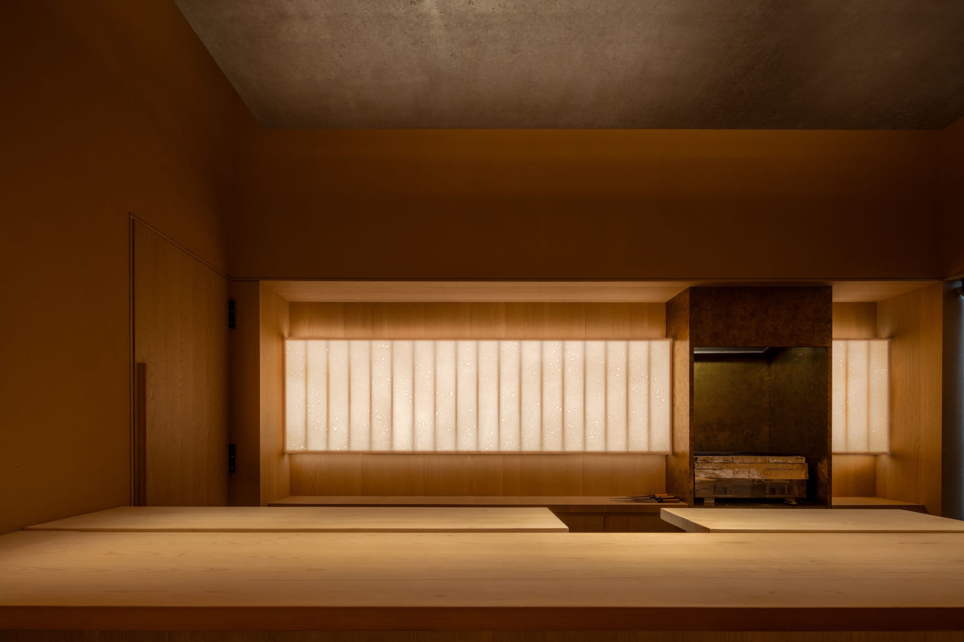 A modern restaurant interior with wooden tables and warm lighting.
