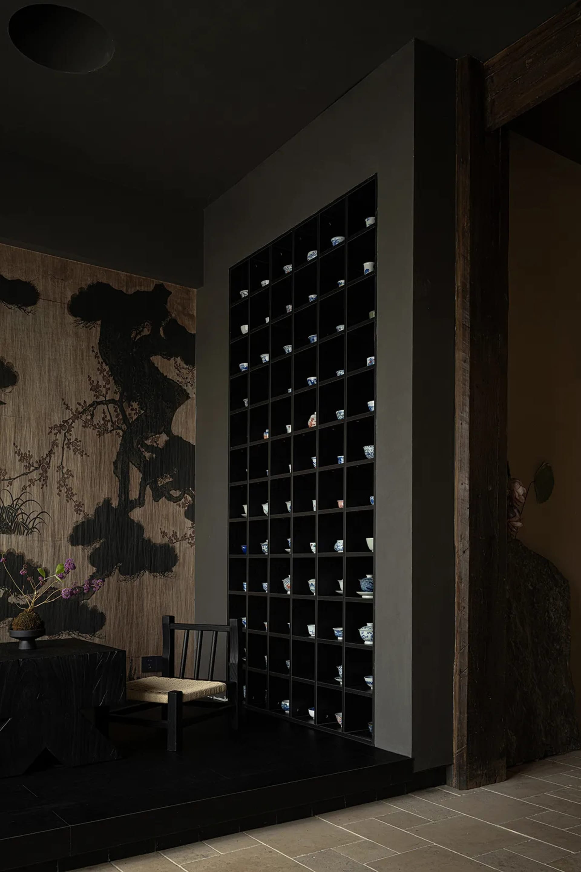 An interior design featuring black wooden furniture and stone flooring.