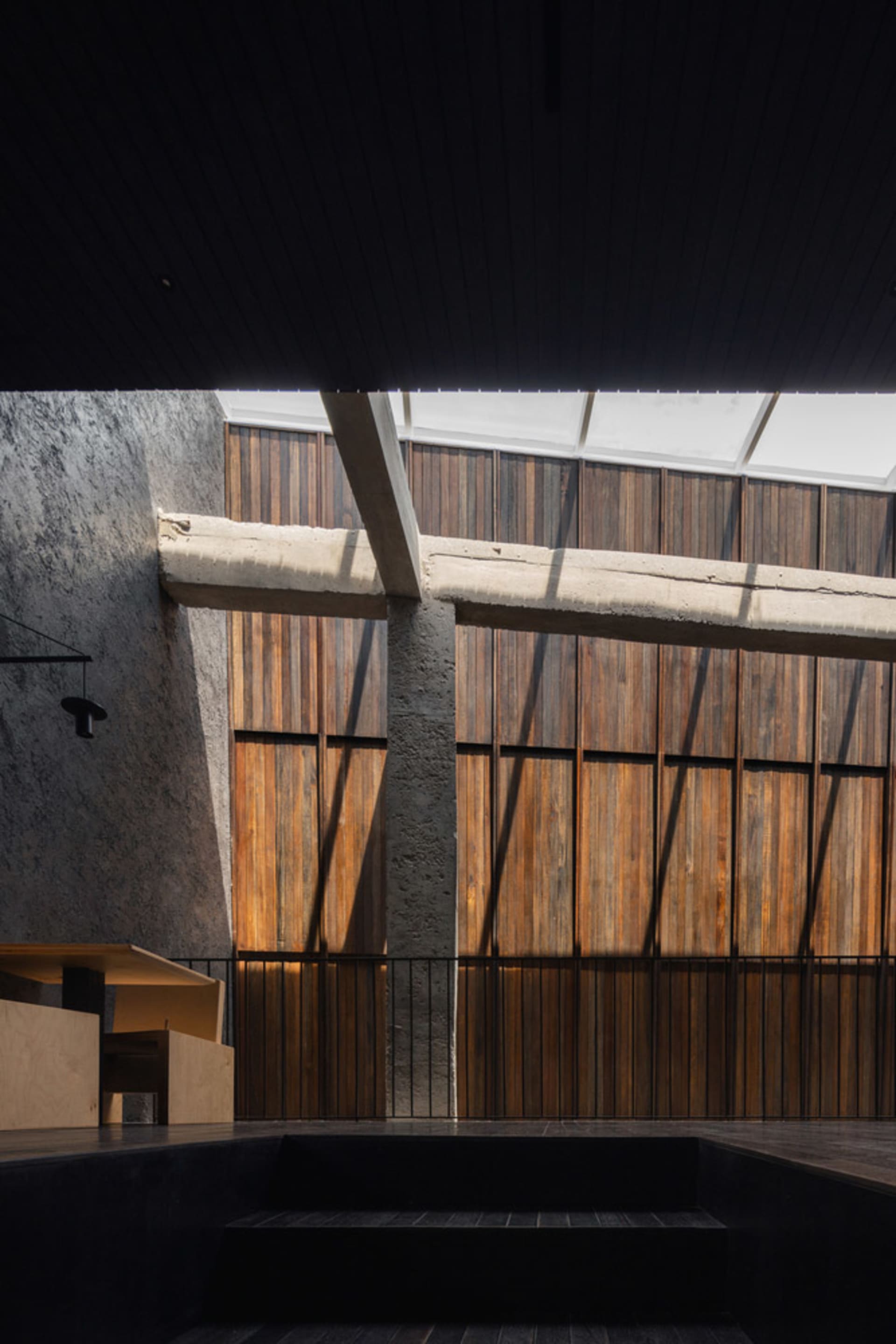 A modern architectural space featuring wooden panels and concrete structural elements.