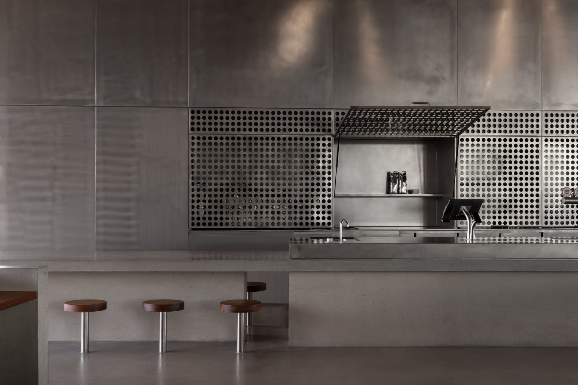 Modern kitchen bar featuring metallic and concrete materials with industrial design elements