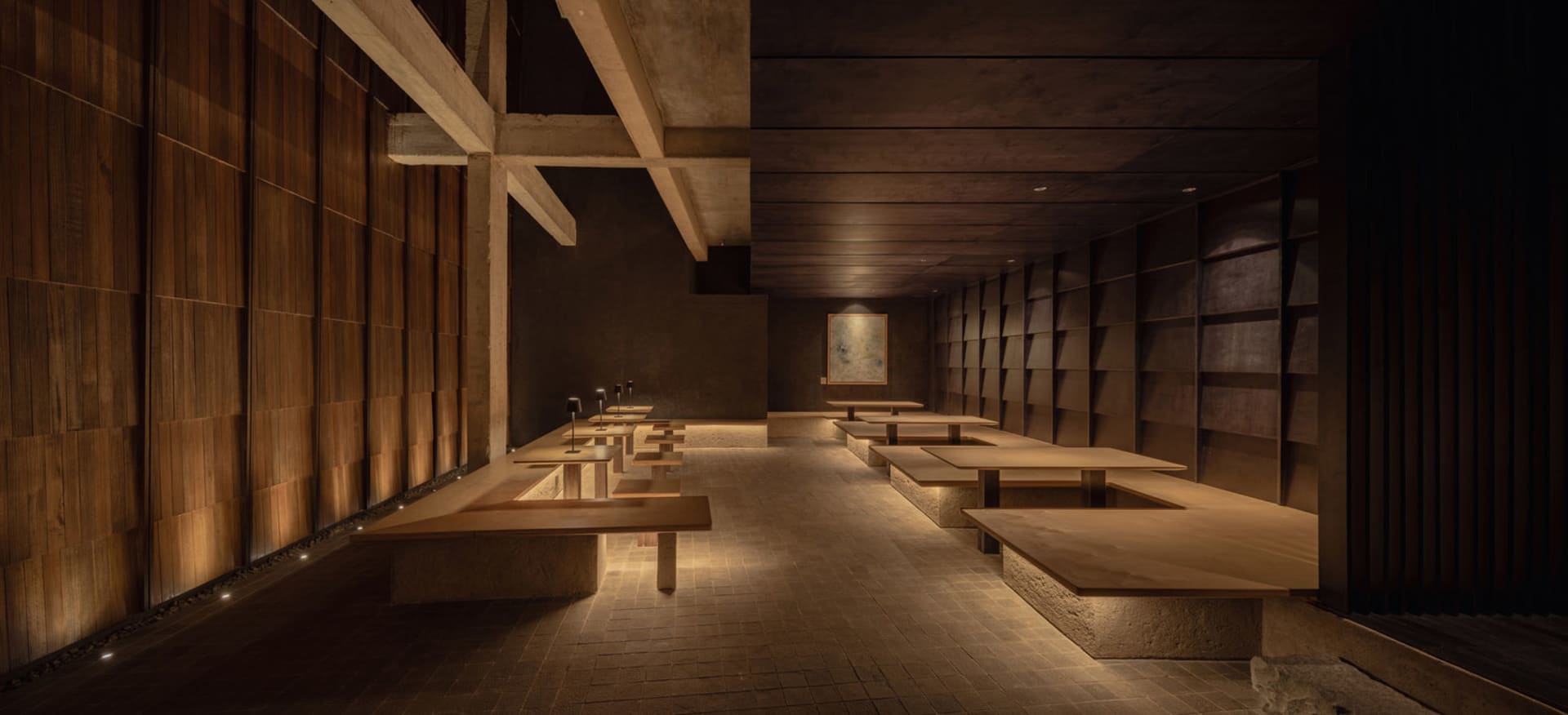 A spacious industrial-style restaurant with wooden tables and seating.