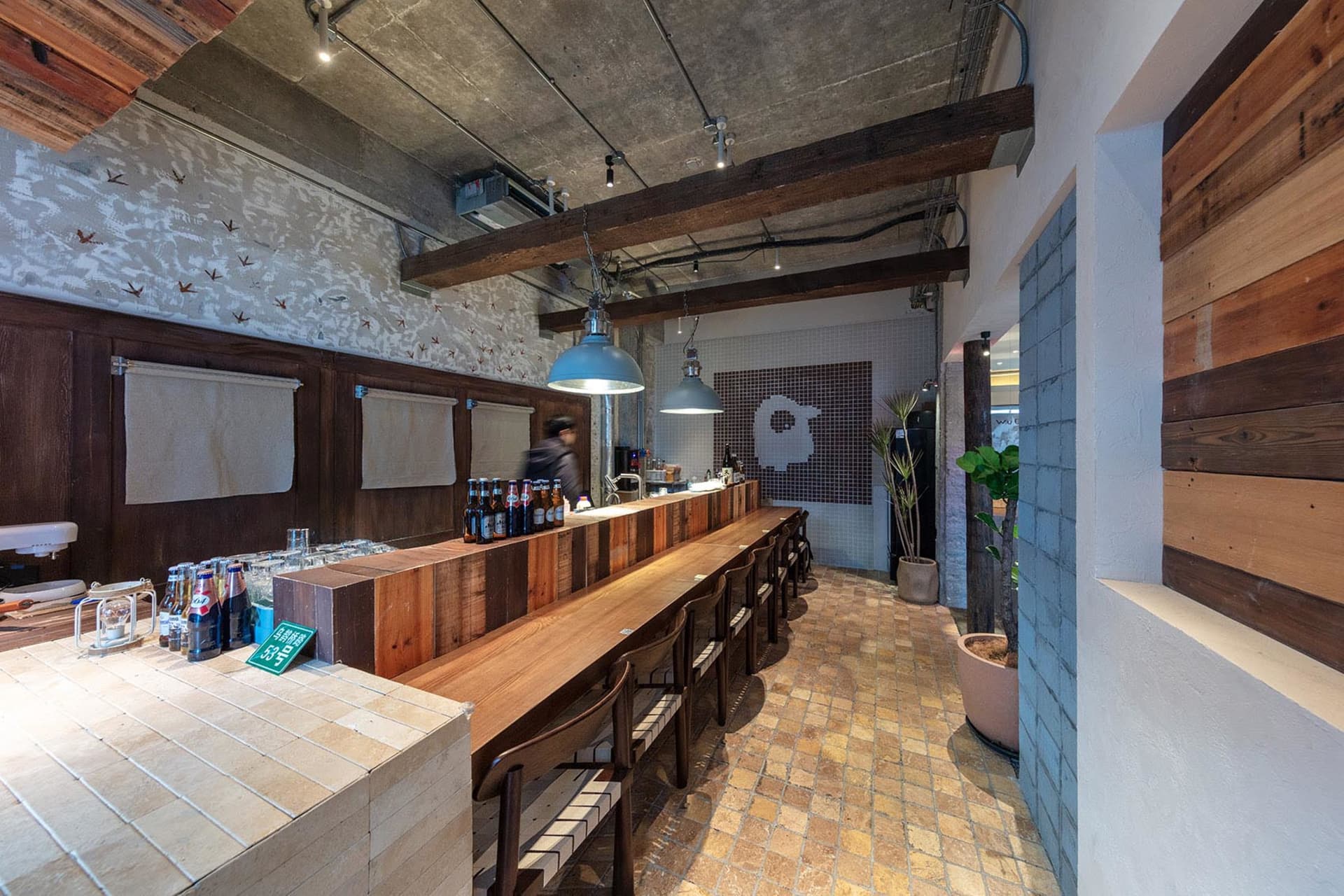 Industrial-style restaurant with wooden seating and concrete and brick walls.