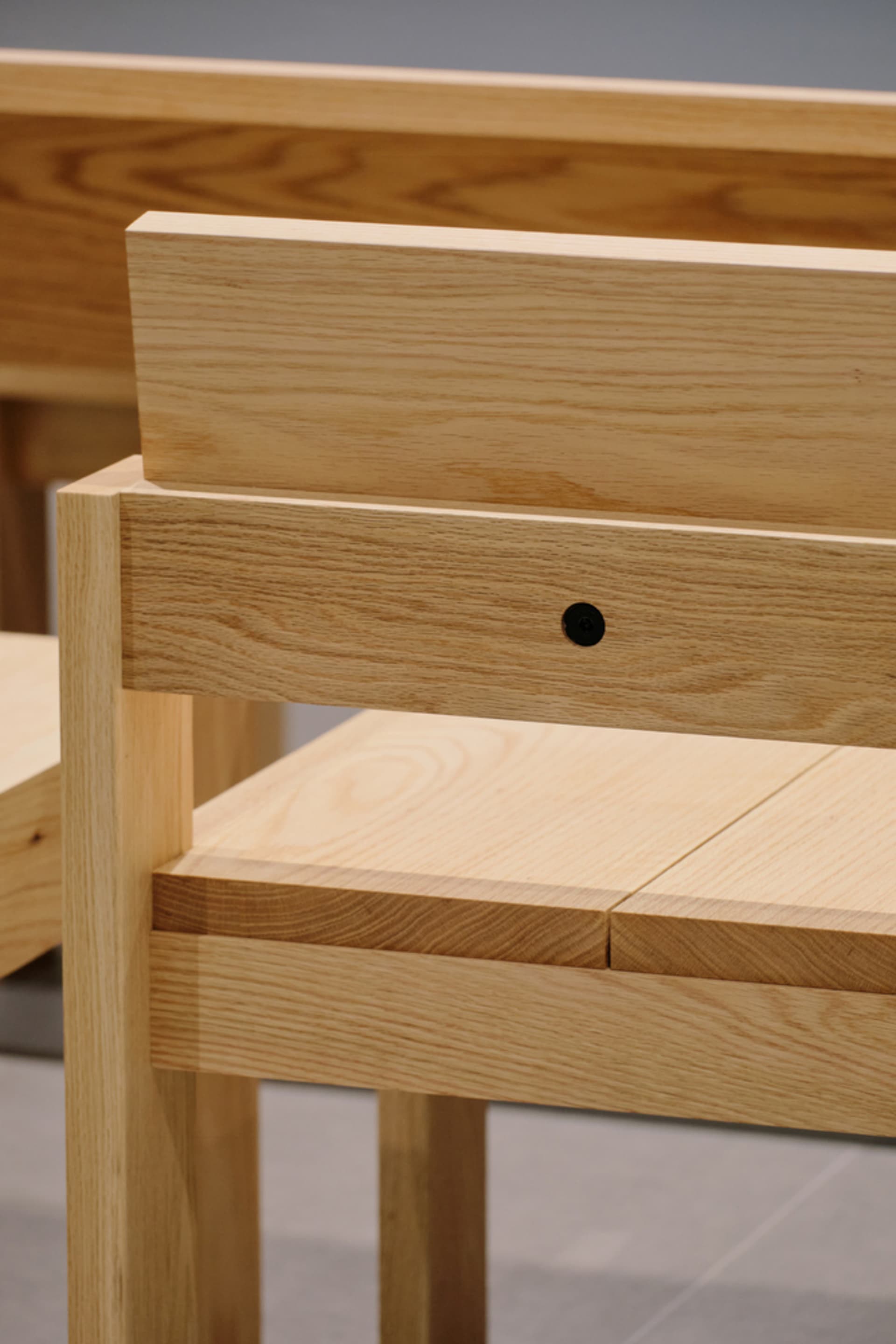 A modern minimalist wooden chair with a sleek, simple design.