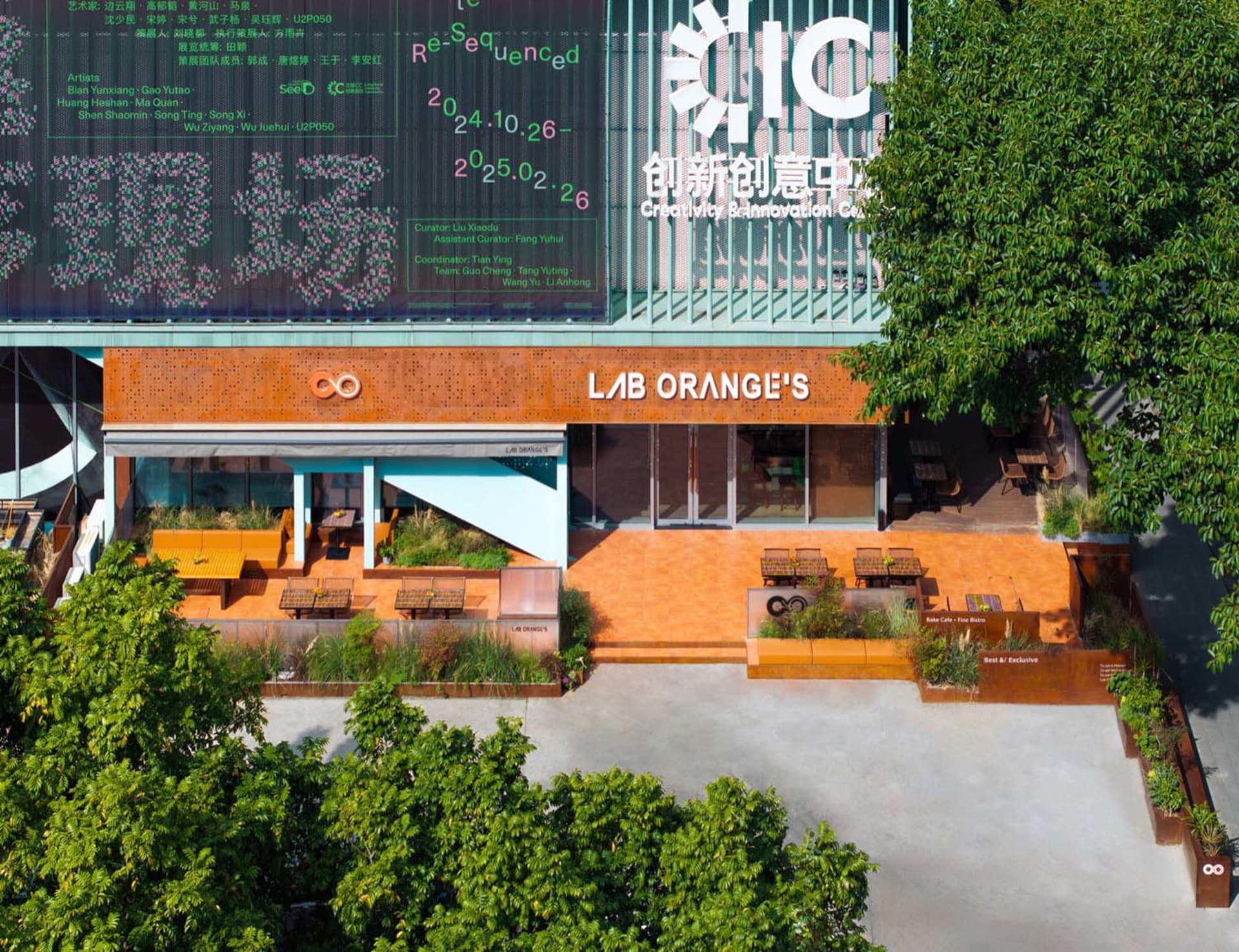 An outdoor seating area of a modern coffee shop with concrete walls and a terracotta facade.