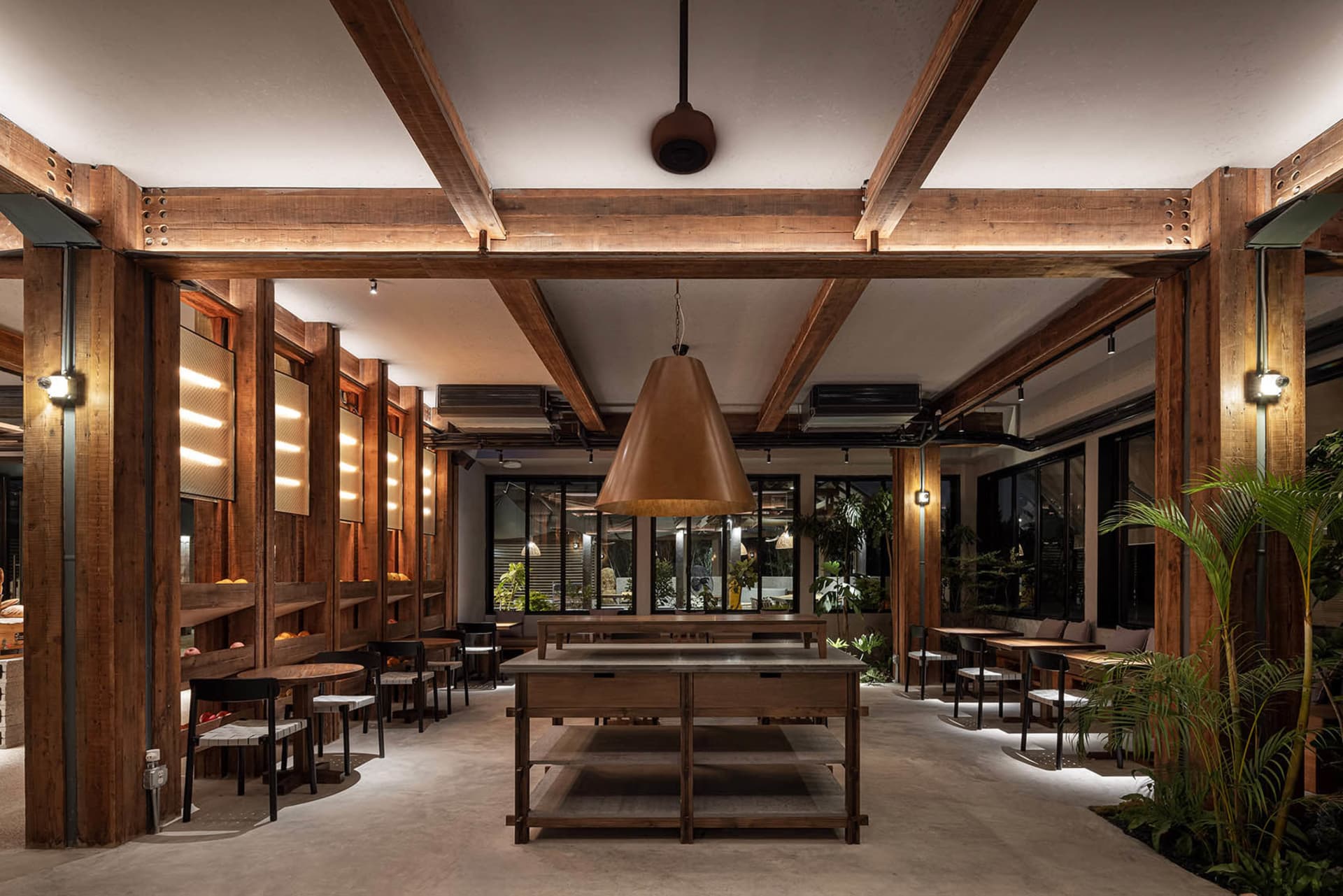 A warm and inviting cafeteria interior with wooden walls and fixtures, featuring a central table and seating arrangements.