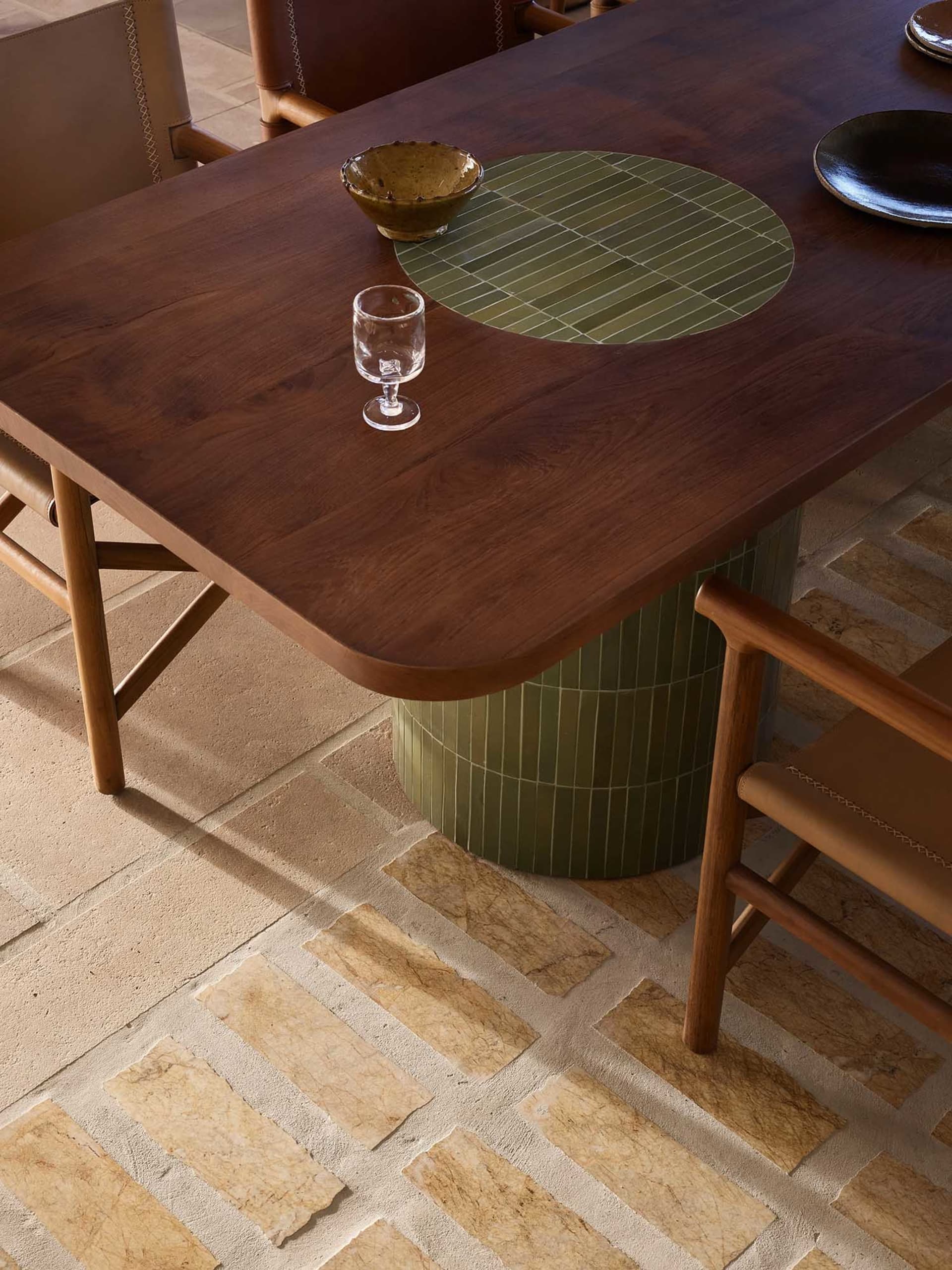 A modern dining room featuring wooden furniture and a glass drink container.