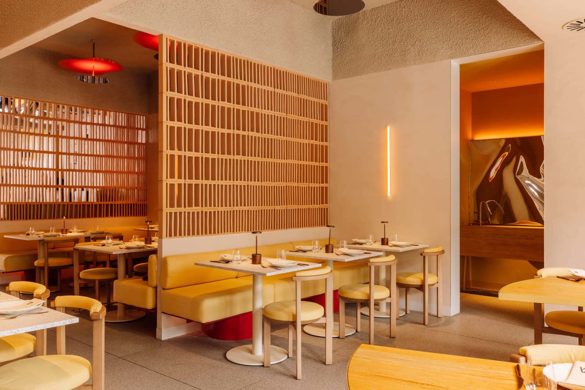 Modern minimalist restaurant interior with sleek, yellow furniture, and contemporary design features.