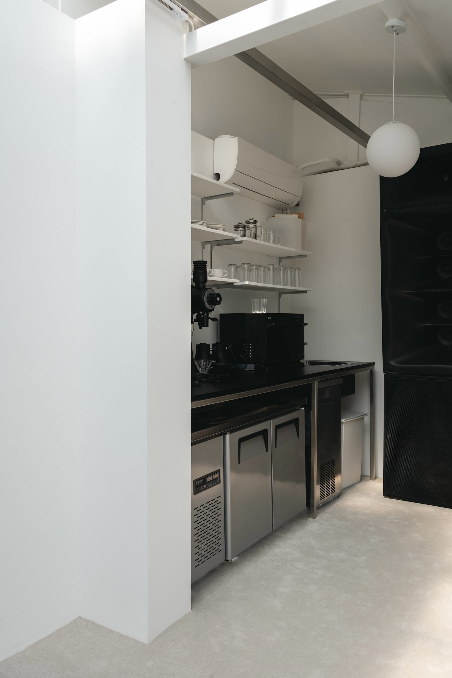 A modern minimalist kitchen featuring metal cabinets and countertops.