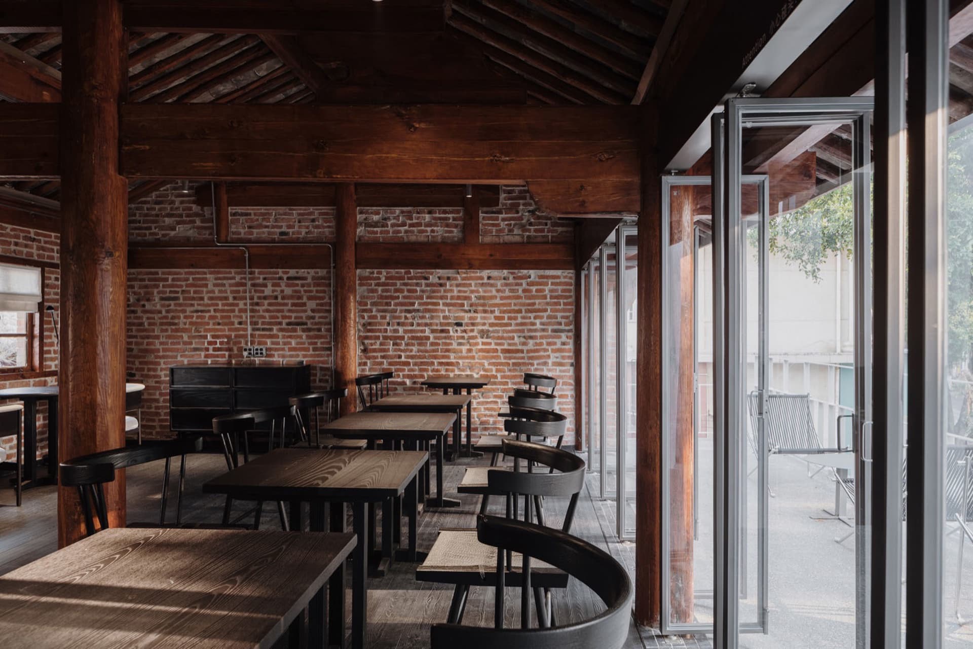 Industrial-themed restaurant featuring exposed brick walls and wooden furniture.
