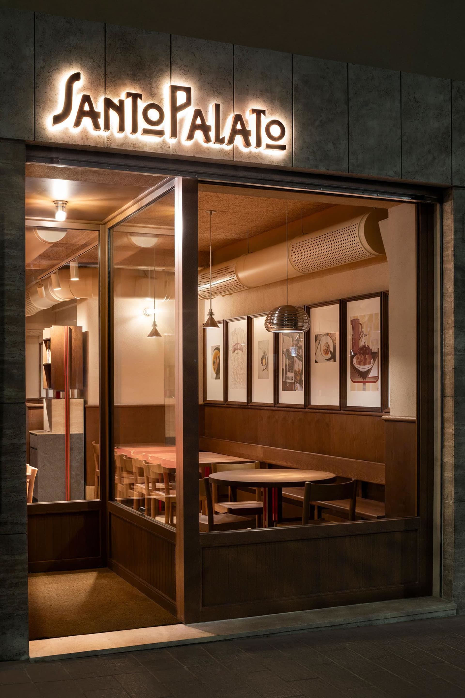 Modern coffee shop interior with wooden elements and framed art hanging on the wall.