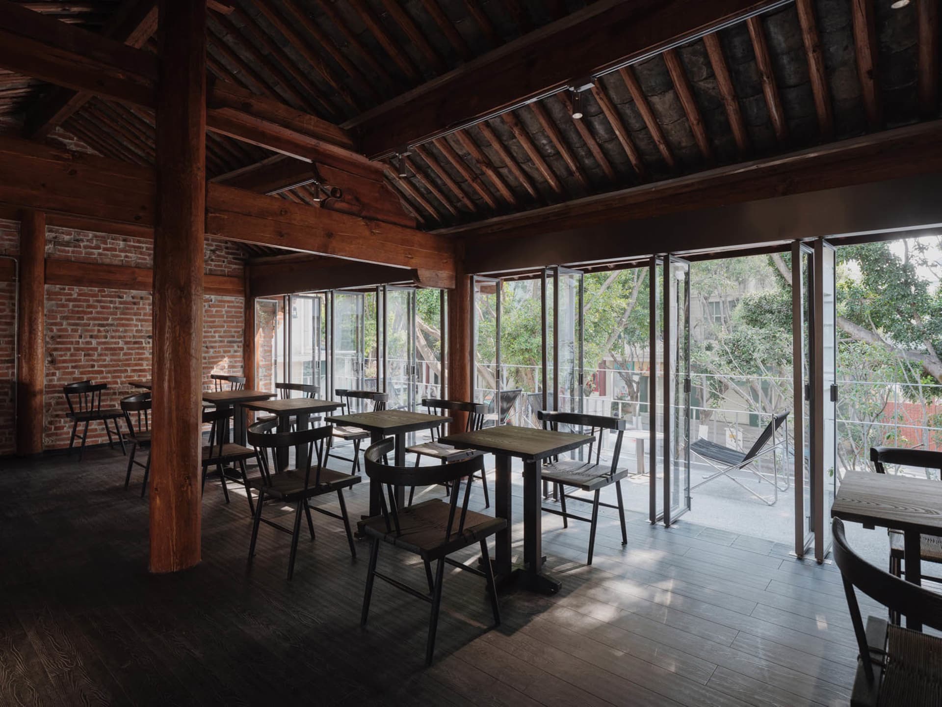Industrial-style coffee shop interior with exposed wooden beams and brick walls.