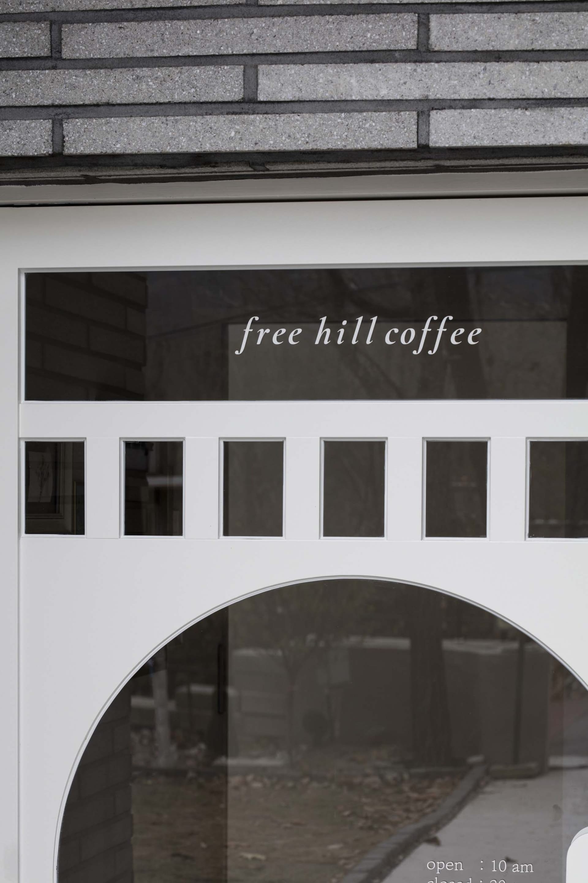 A glass storefront sign with the text 'free hill coffee'.