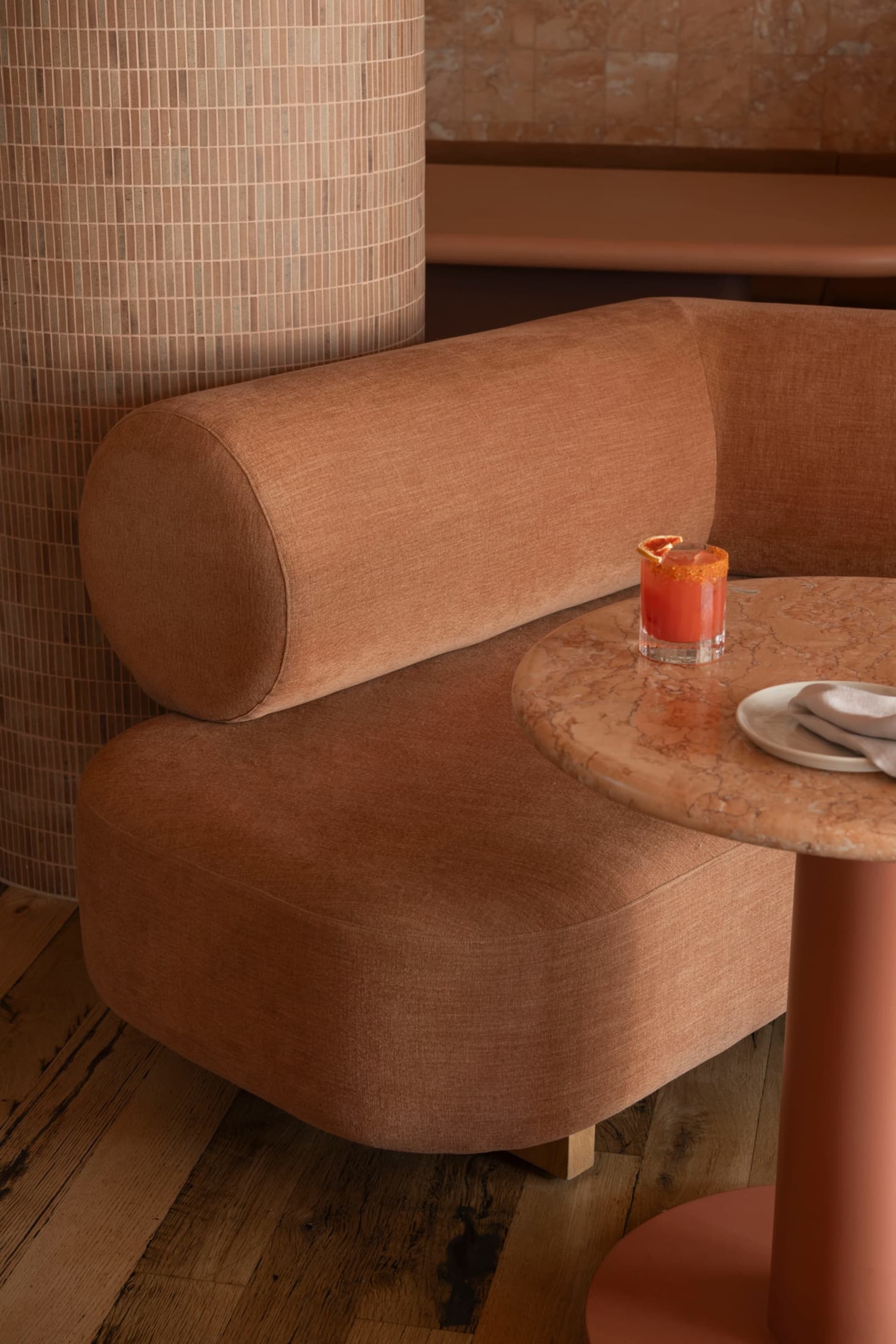 A cozy cafe with comfortable seating, a marble round table, and wooden accents.