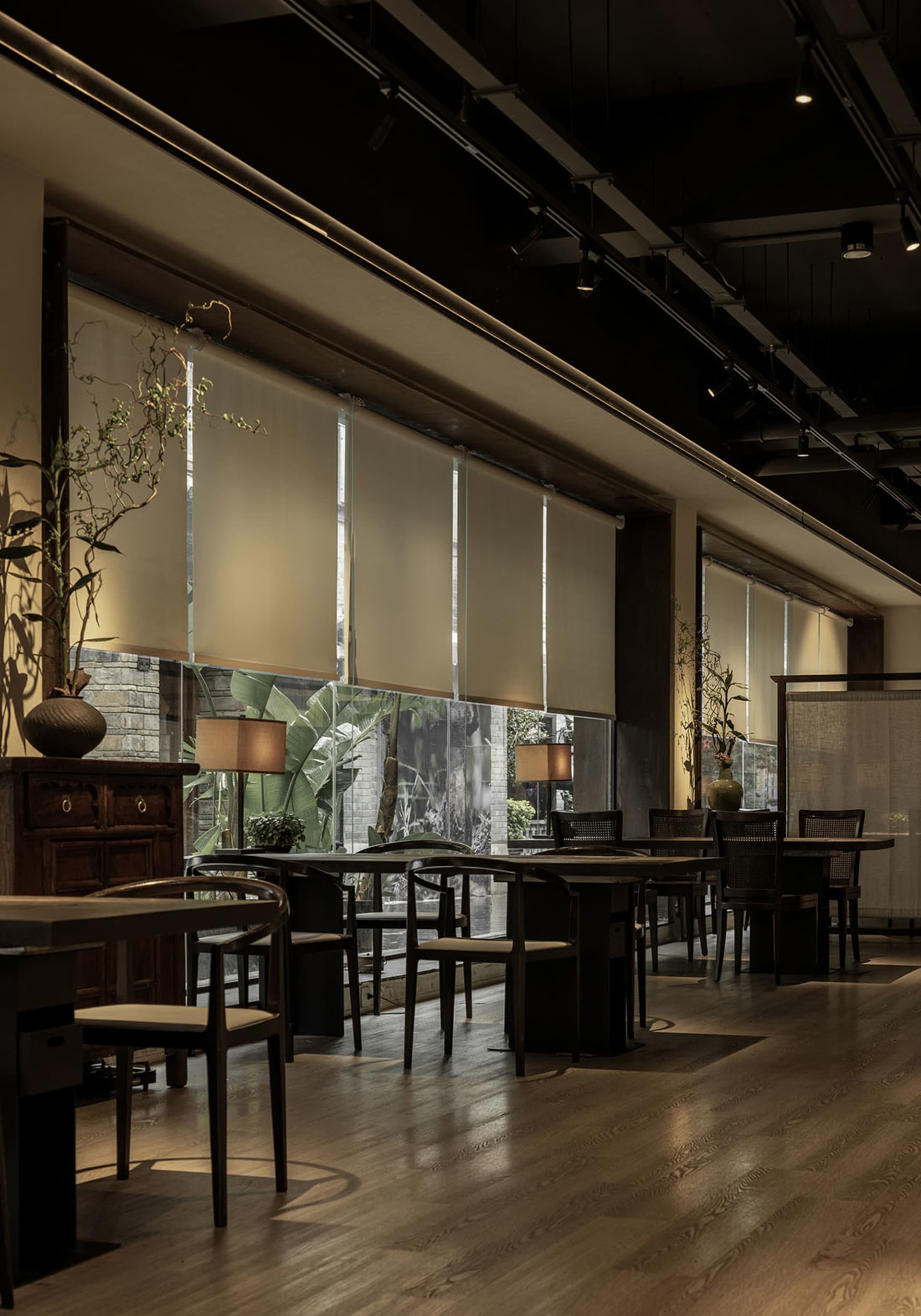 工業風主題餐廳室內,配有木製餐桌椅、玻璃牆與自然光線。