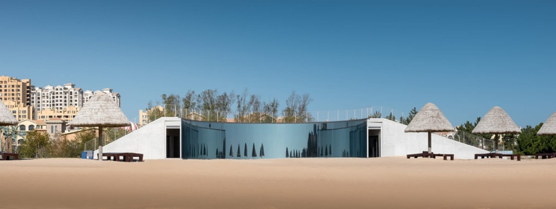 Modern glass house on a sandy beach