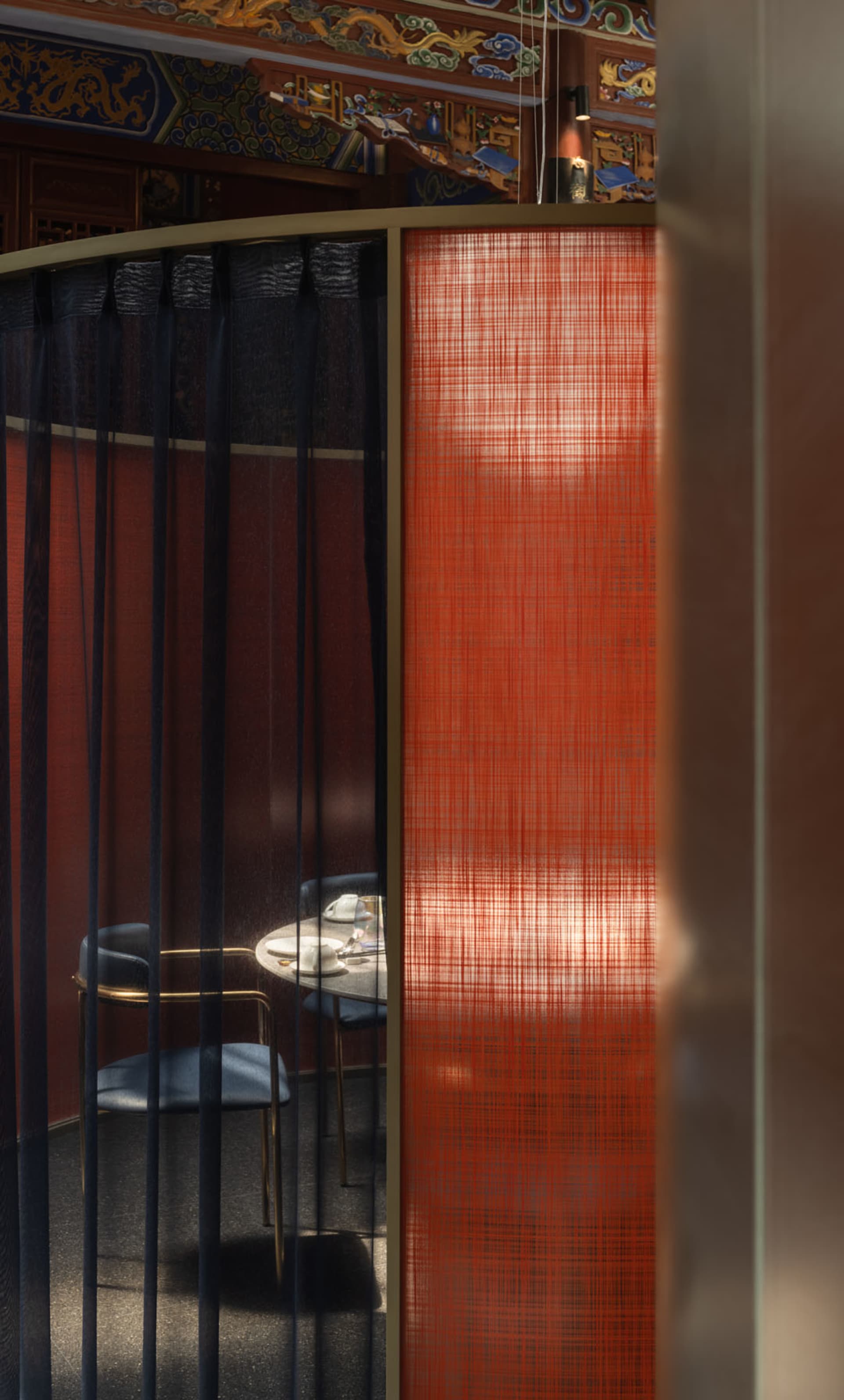 A modern minimalist restaurant booth with red fabric and black accents.