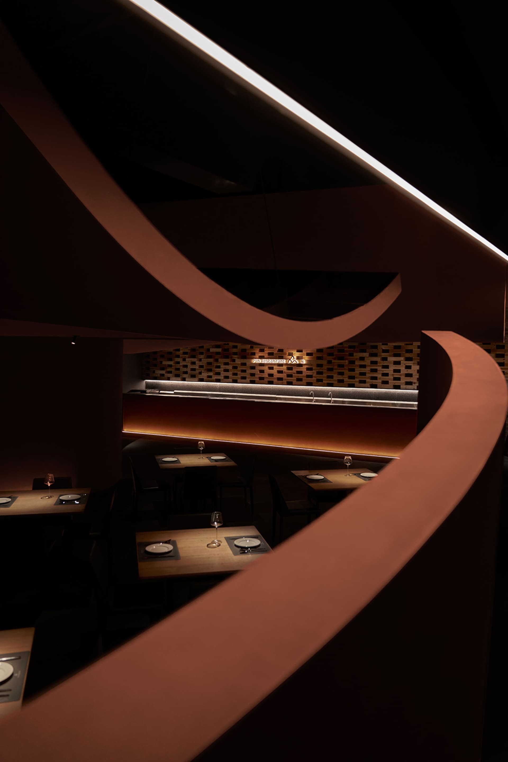 現代餐廳室內空間,搭配木質餐桌與餐椅,由線型吊燈散發溫暖氛圍光。